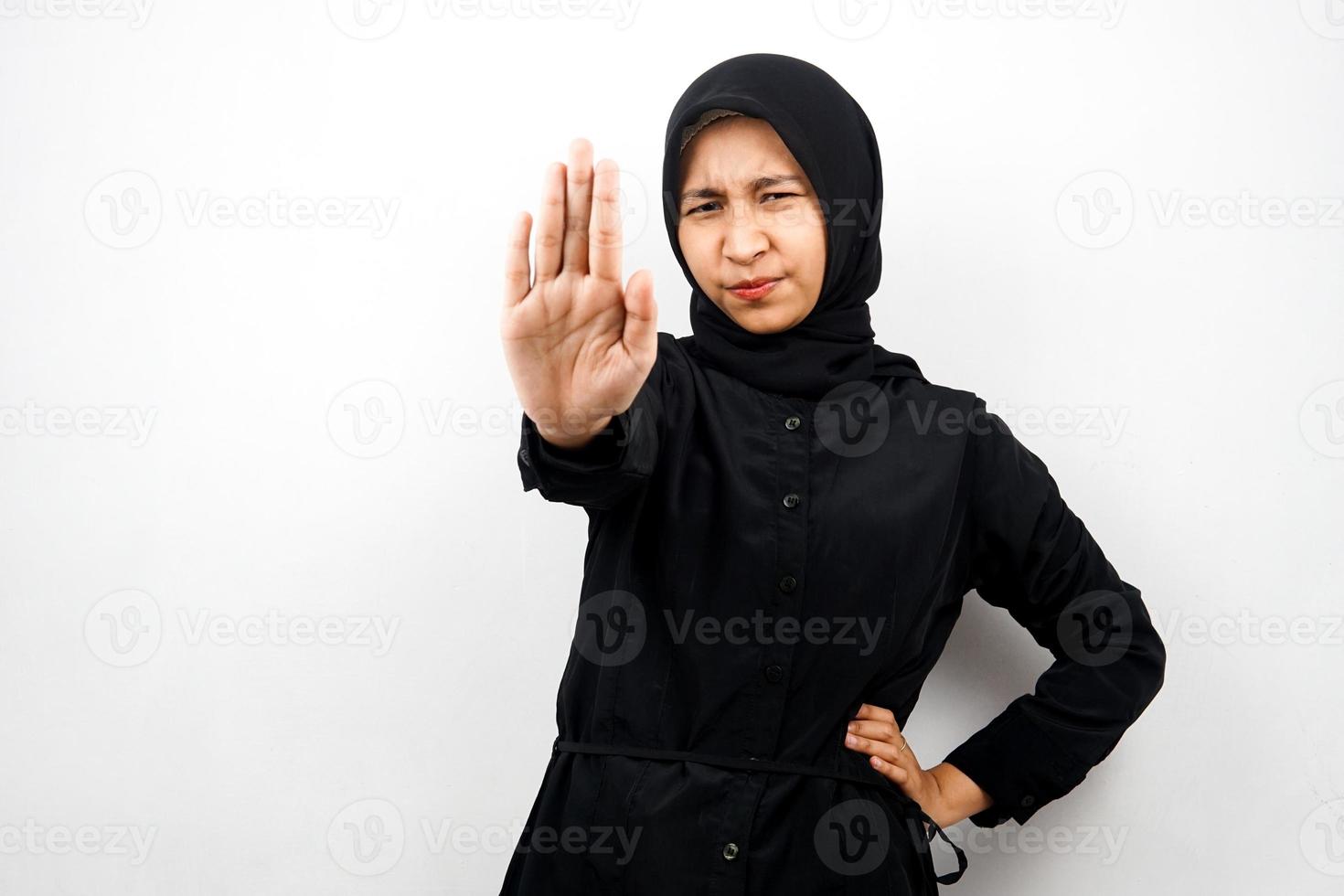 Hermosa joven mujer musulmana asiática con expresión seria, rechazando algo, mirando a la cámara aislada sobre fondo blanco. foto