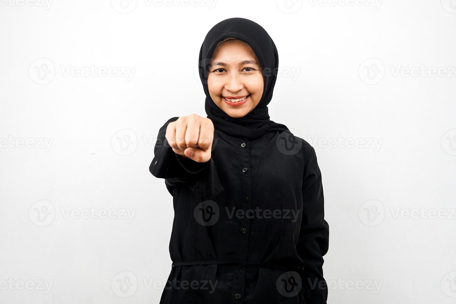 Hermosa joven musulmana asiática sonriendo confiada, entusiasta y alegre con los puños apretados a la cámara, puñetazos, peleas, cooperación, ojos brillantes, mirando a cámara aislada foto