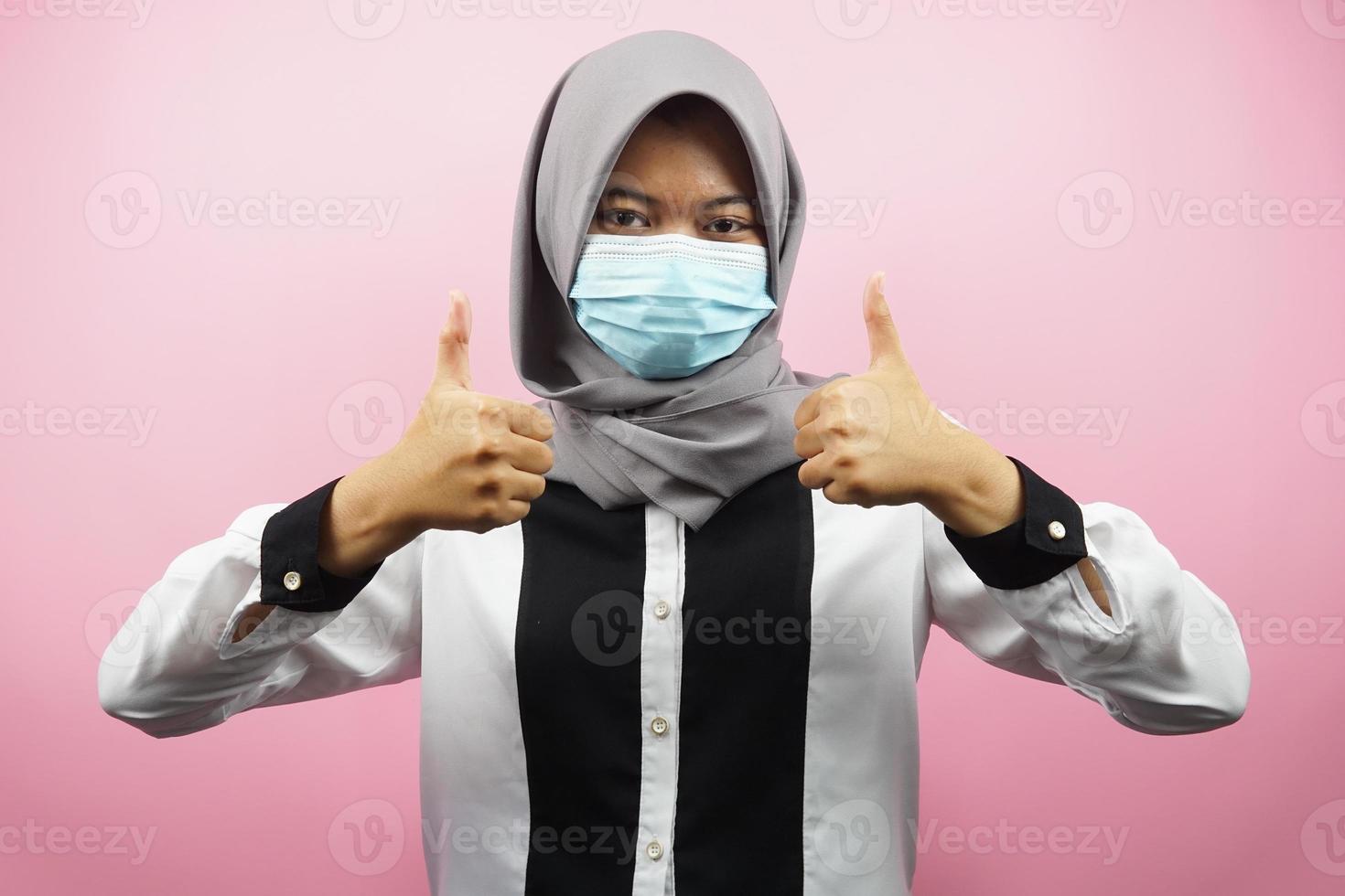 mujer musulmana con máscaras médicas, movimiento contra el virus corona, movimiento anti covid-19, movimiento de salud con máscaras, con las manos mostrando el signo de ok, buen trabajo, éxito, victoria, aislado foto