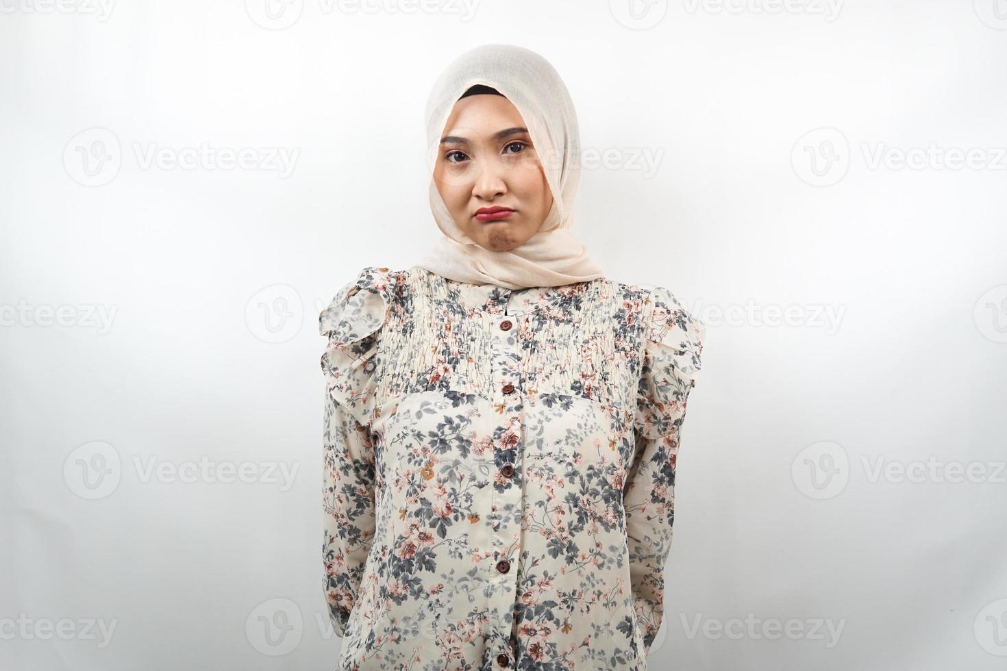 Hermosa joven musulmana asiática haciendo pucheros mirando a la cámara aislada sobre fondo blanco. foto