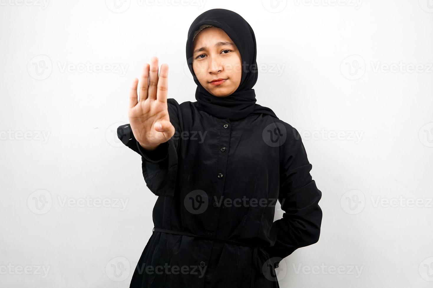 Hermosa joven musulmana asiática con la mano de la señal de pare, rechazar la mano de la señal, mano de la señal de prohibición, no acercarse a la mano, mantenerse alejado de la mano del signo, no mover la mano del signo, aislado sobre fondo blanco. foto