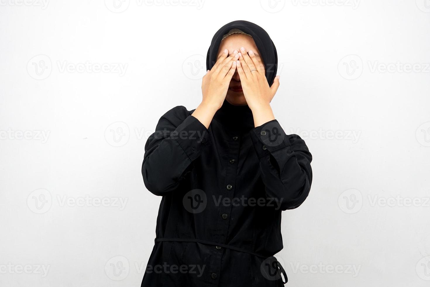 Beautiful young asian muslim woman with hands closing eyes, isolated on white background photo