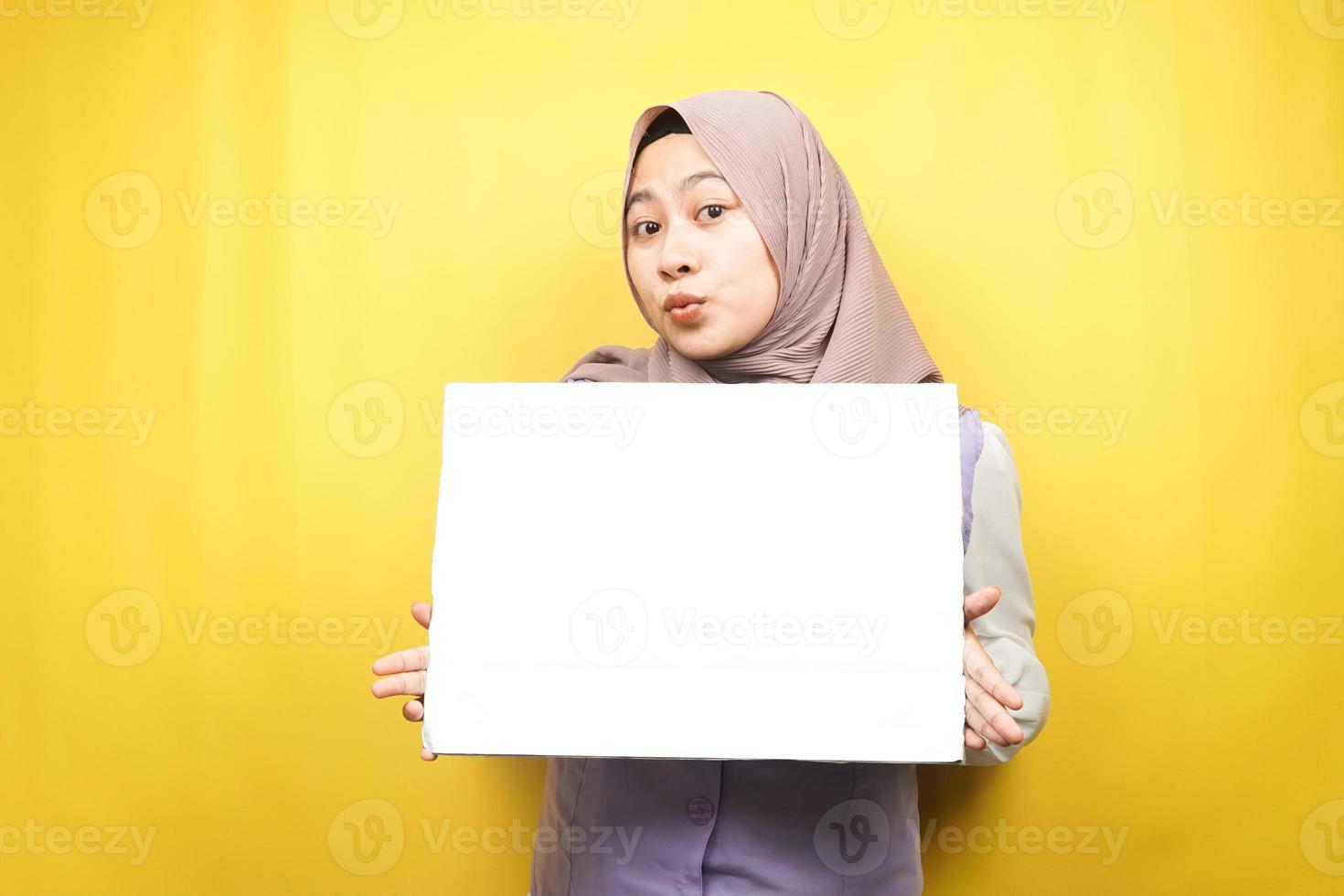 Bastante joven mujer musulmana conmocionada, sorprendida, guau, mano sosteniendo pancarta vacía en blanco, cartel, tablero blanco, tablero de letrero en blanco, tablero de anuncio blanco, presentando algo en el espacio de la copia, promoción foto