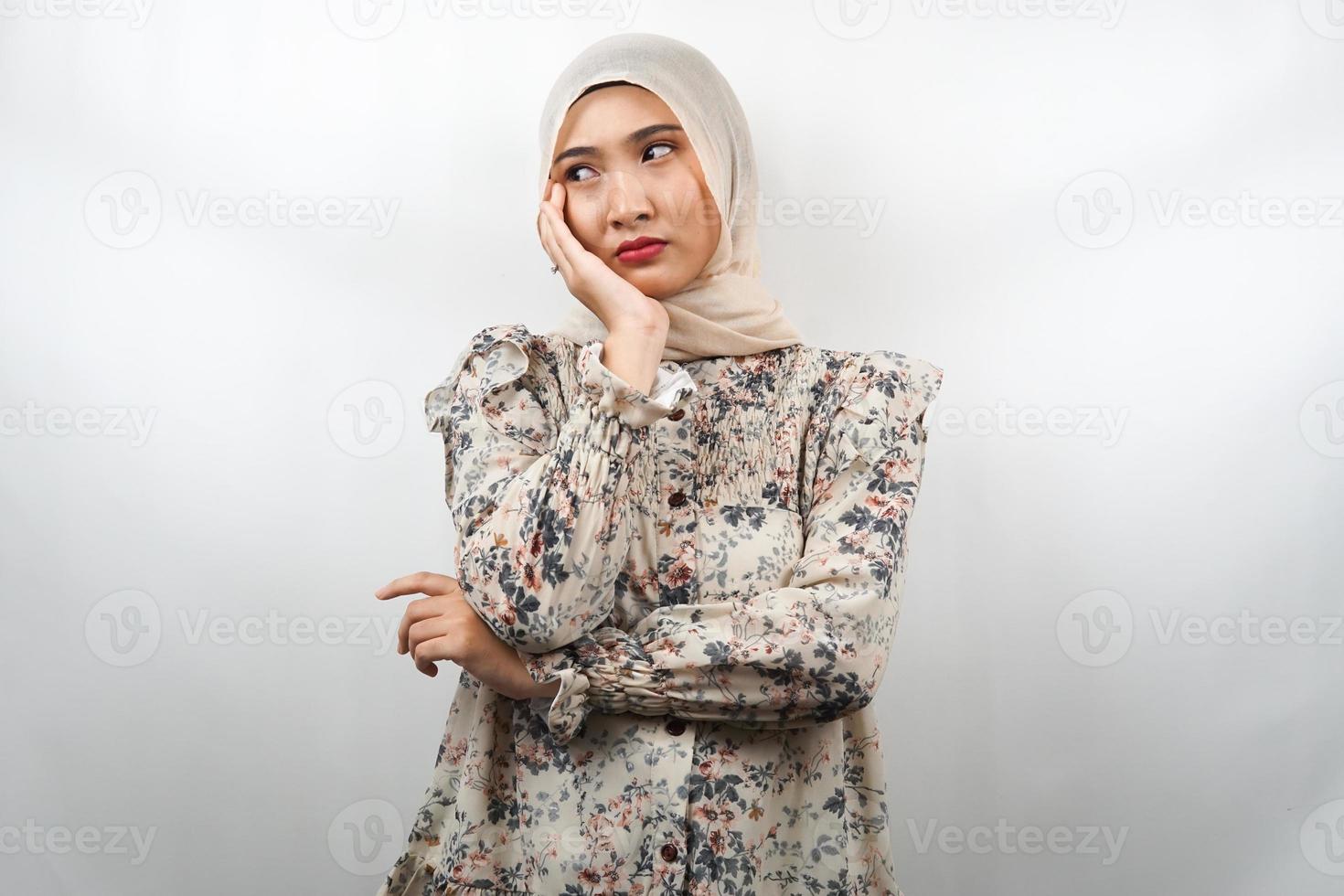 Beautiful asian young muslim woman thinking, looking for ideas, looking for solutions to problems, with hands holding cheeks, isolated on white background photo