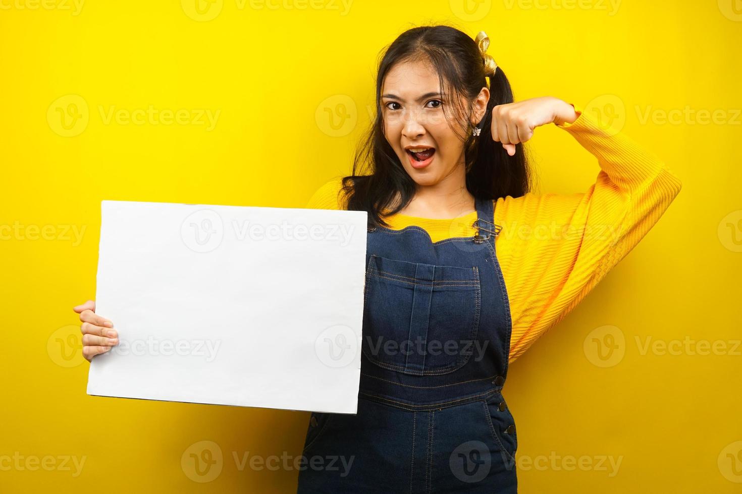 Bonita y linda mujer joven sosteniendo pancarta vacía en blanco, cartel, tablero blanco, tablero de letrero en blanco, tablero de anuncio blanco, presentando algo en el espacio de la copia, promoción foto