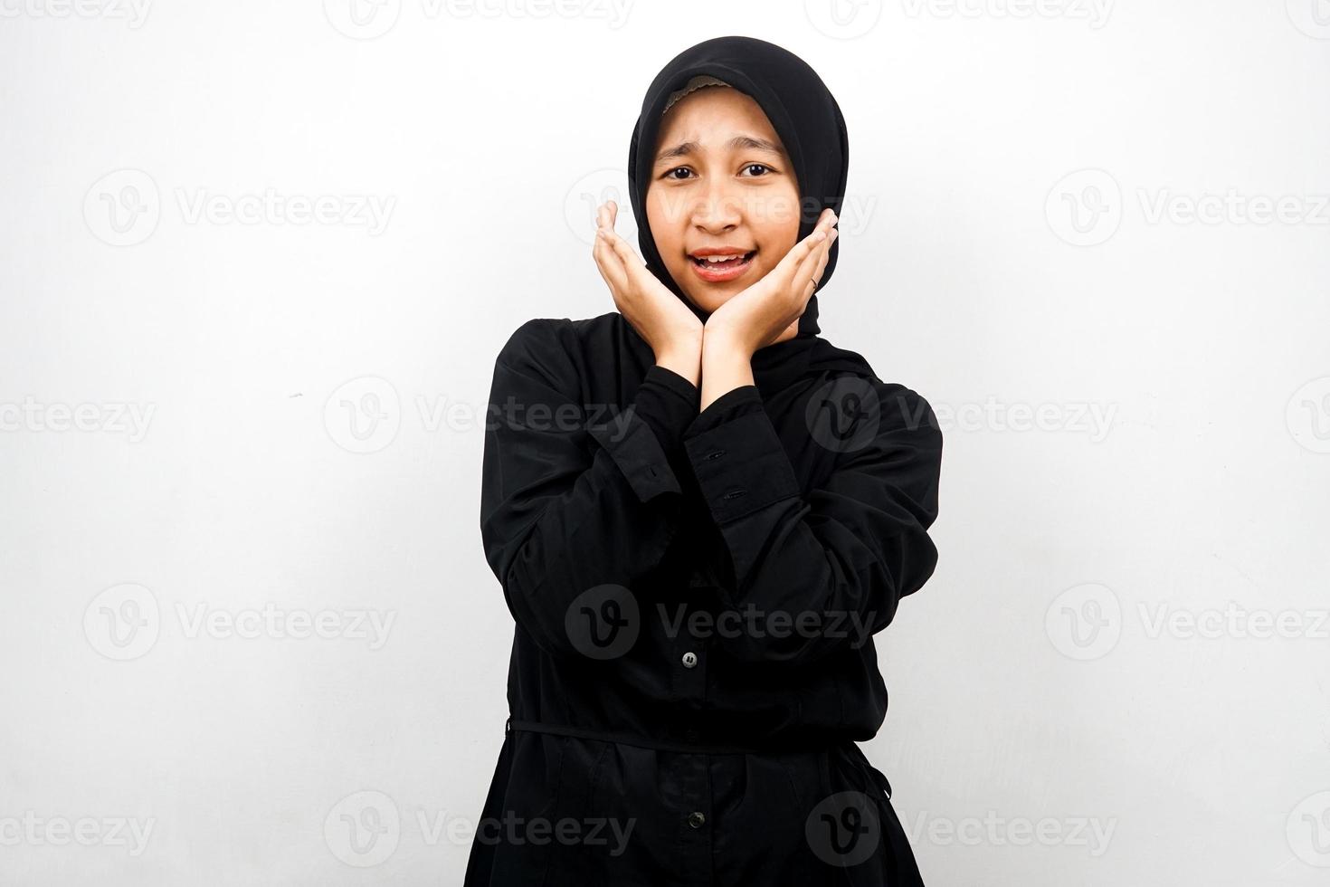 Hermosa joven mujer musulmana asiática conmocionada, sorprendida, wow expresión, con la mano que sostiene la mejilla frente a la cámara aislada sobre fondo blanco. foto
