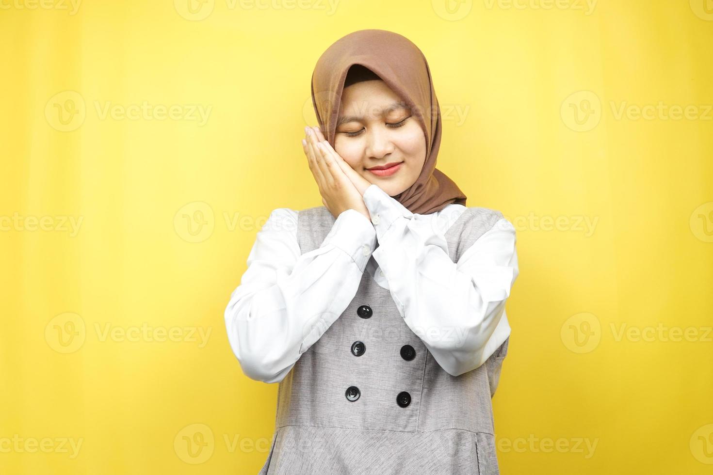 Hermosa joven musulmana asiática durmiendo pacíficamente, sintiéndose cómoda, sintiéndose feliz, aislada sobre fondo amarillo foto