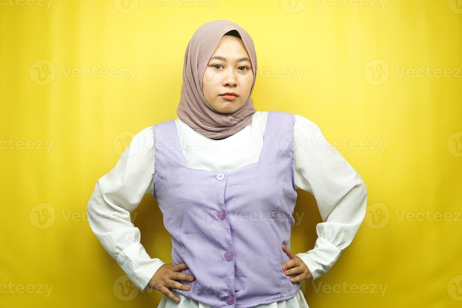 Beautiful young asian muslim woman pouting, angry, feeling annoyed, dissatisfied, uncomfortable, feeling bullied, lied to, looking at camera isolated on yellow background photo