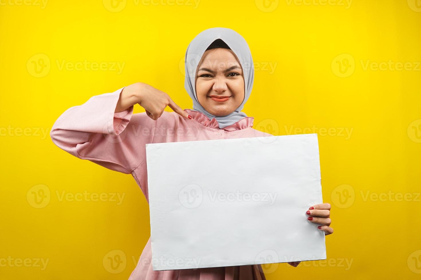 Bastante joven mujer musulmana alegre sosteniendo pancarta vacía en blanco, cartel, tablero blanco, tablero de letrero en blanco, tablero de anuncio blanco, presentando algo en el espacio de la copia, promoción foto