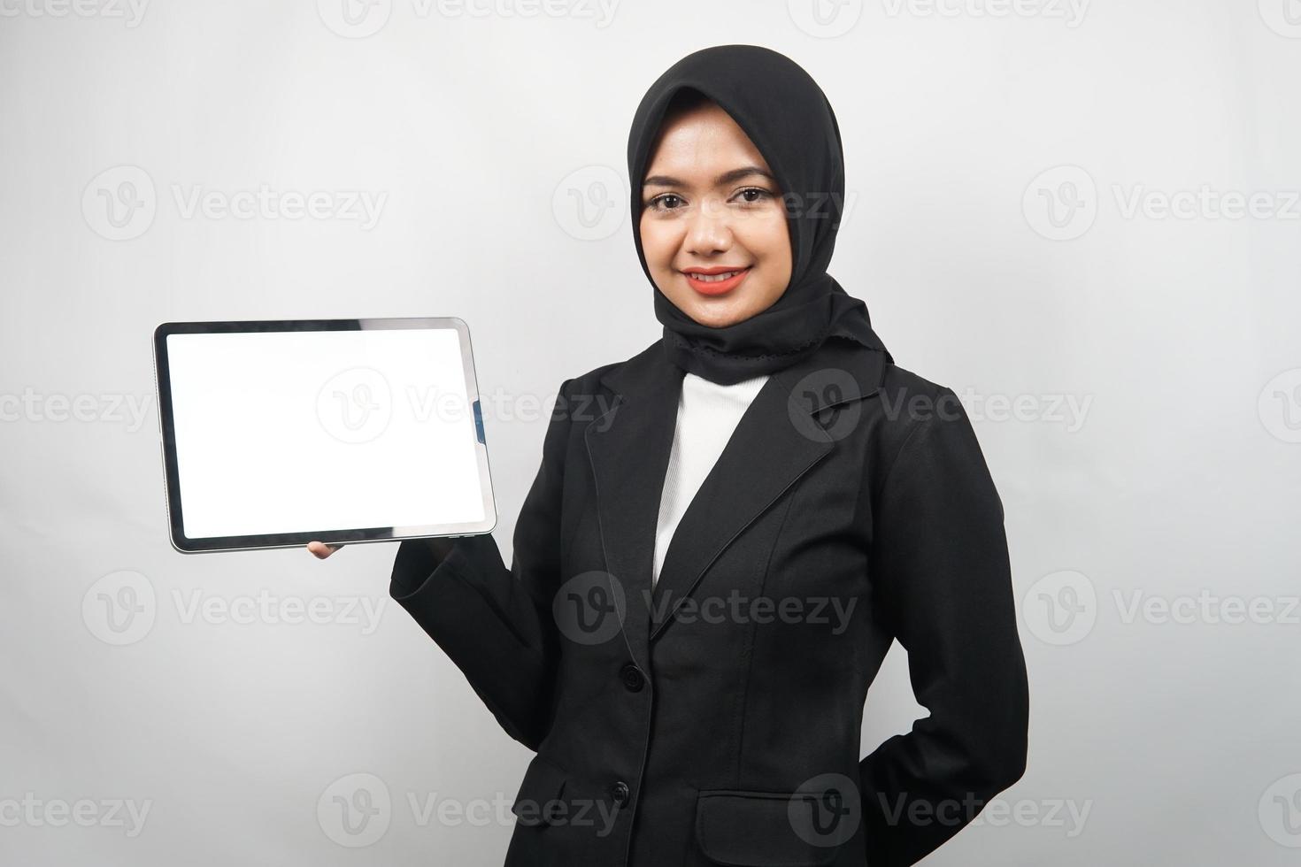 Hermosa joven mujer de negocios musulmana asiática confiada y sonriente, manos sosteniendo tableta con pantalla blanca o pantalla en blanco, presentando algo, presentando un producto, presentando un informe, aislado foto