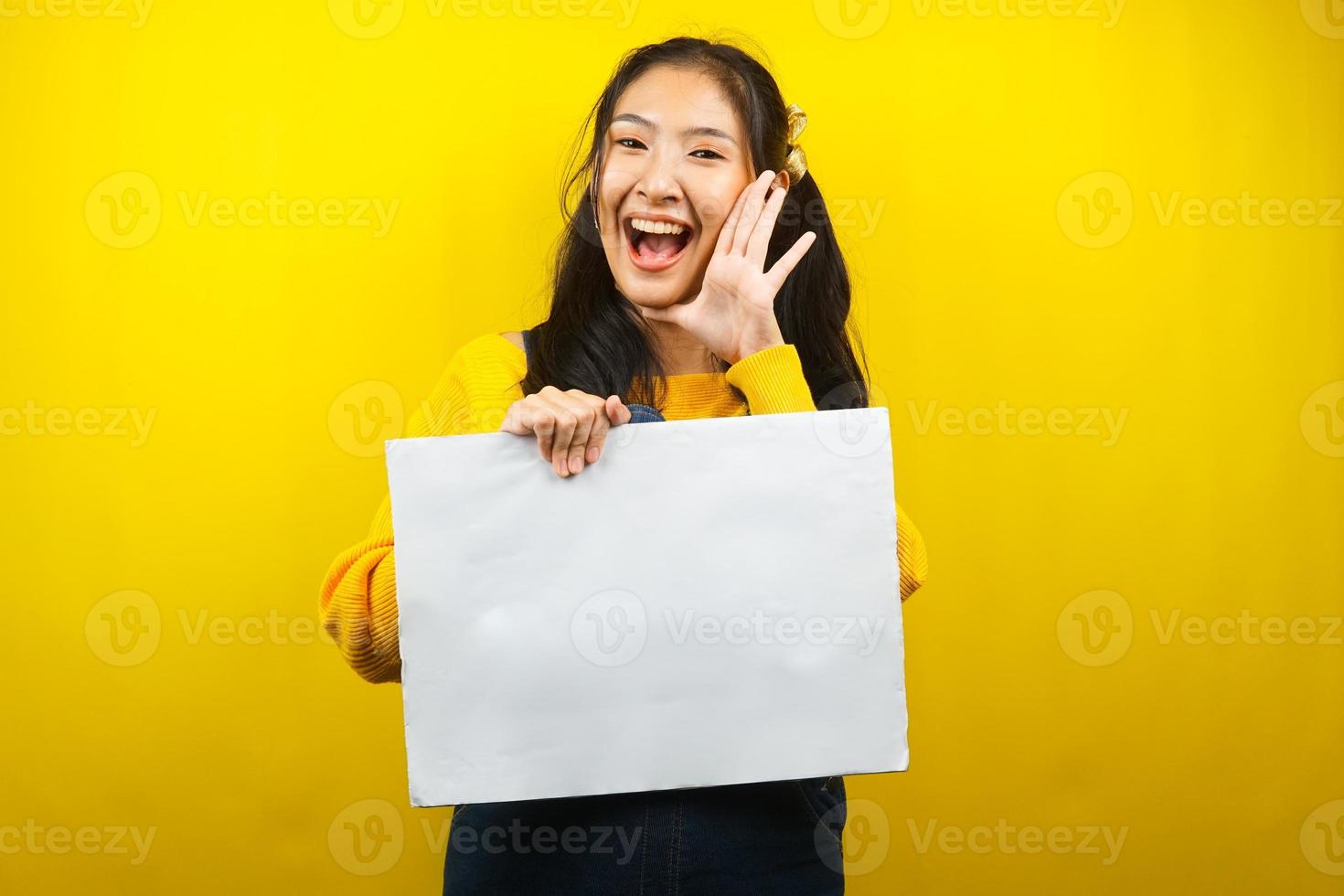 Bonita y linda mujer joven alegre sosteniendo pancarta vacía en blanco, cartel, tablero blanco, tablero de letrero en blanco, tablero de anuncio blanco, presentando algo en el espacio de la copia, promoción foto