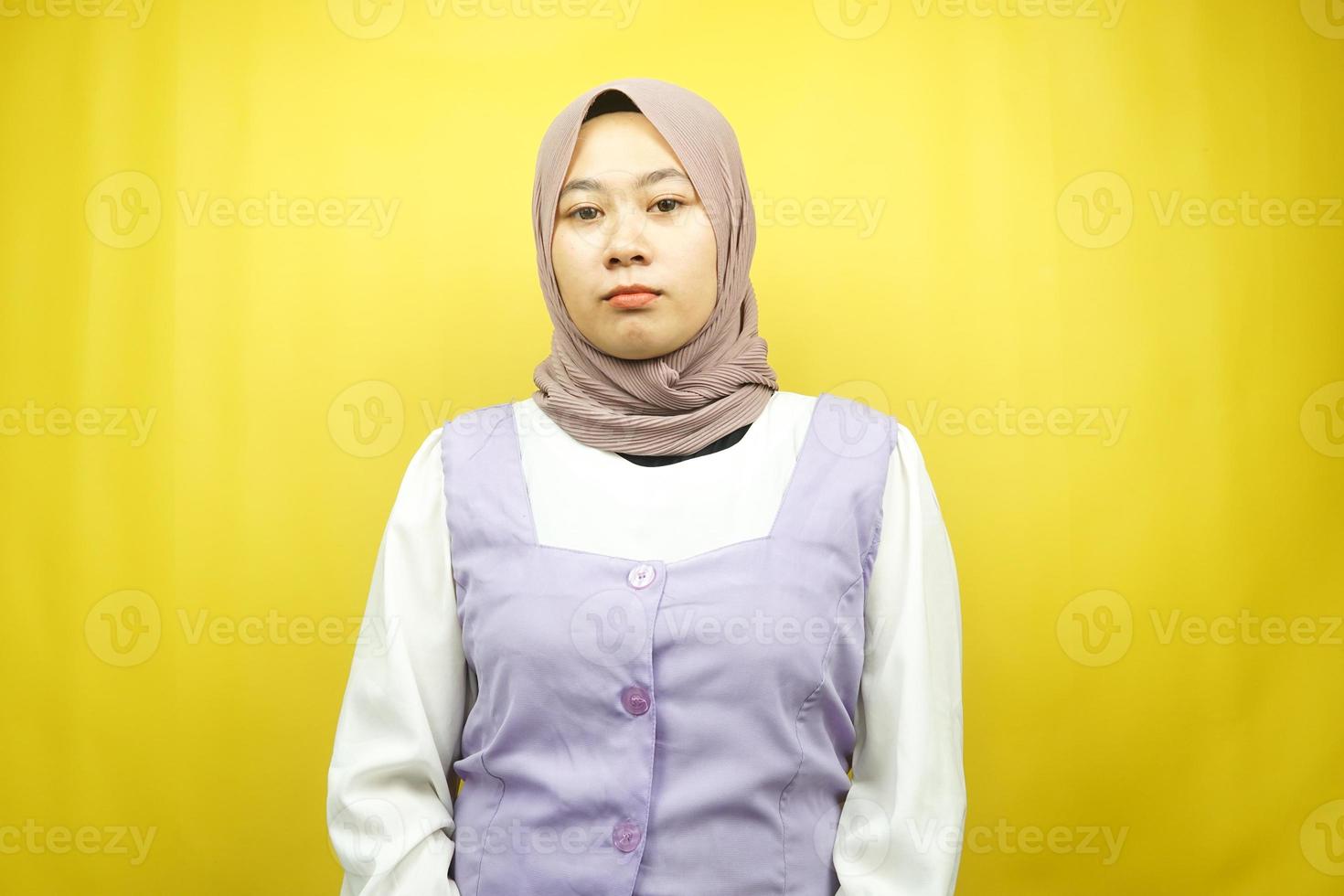 Beautiful asian young muslim woman pouting looking at camera isolated on yellow background photo