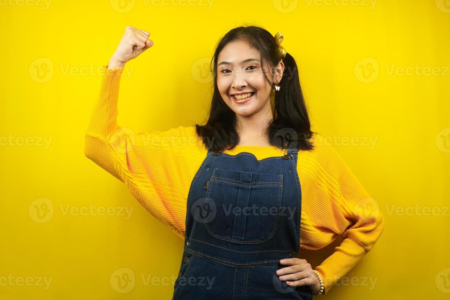 Bonita y linda mujer joven alegre, fuerte, confiada, con la mano apretada firme, lucha, lograr el éxito, la victoria, aislado foto