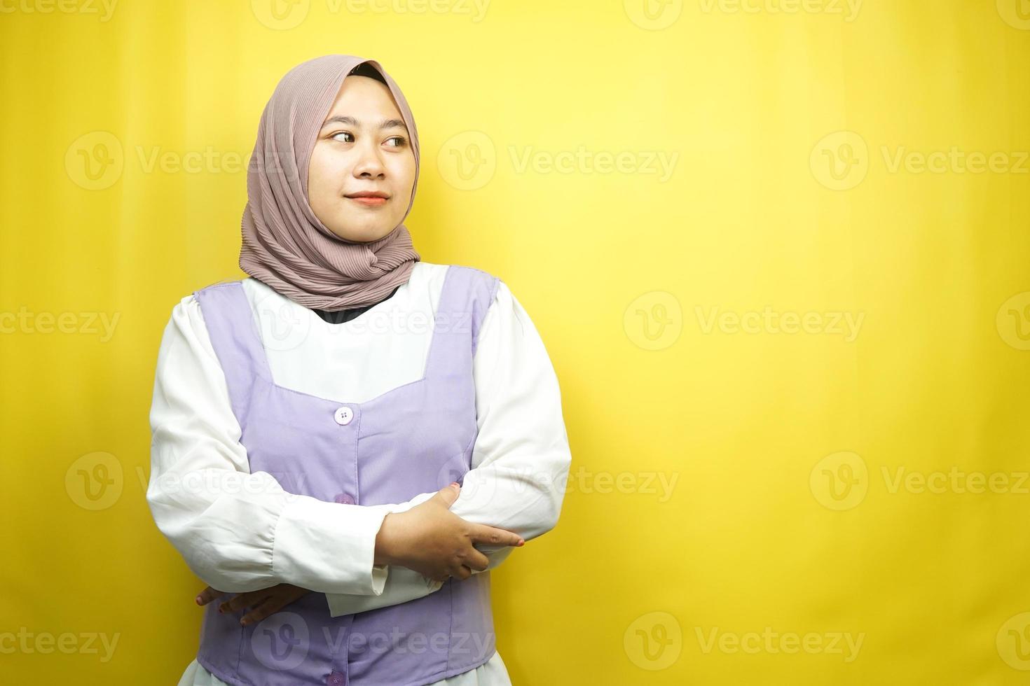 Beautiful young asian muslim woman pouting, feeling dissatisfied, annoyed, unhappy, thinking, something is wrong, facing  empty space isolated on yellow background photo