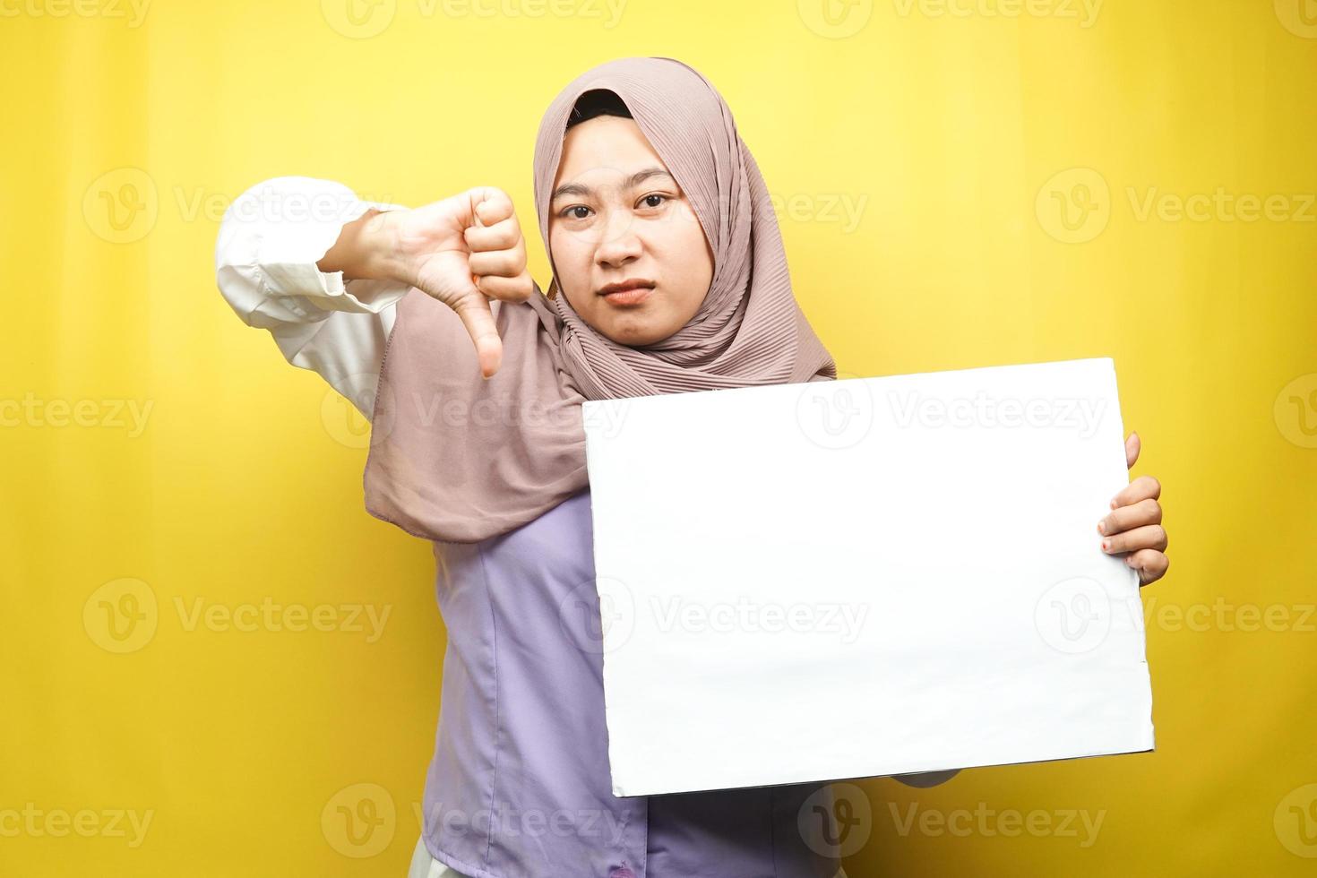 Bastante joven mujer musulmana no le gusta, mano sosteniendo pancarta vacía en blanco, cartel, tablero blanco, tablero de letrero en blanco, tablero de anuncio blanco, presentando algo en el espacio de la copia, promoción foto