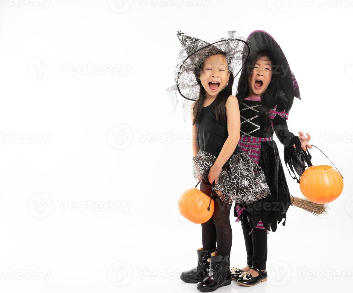 Portrait Asian girls in Halloween costume riding the broom together and holind the pumpkin with isolated background photo