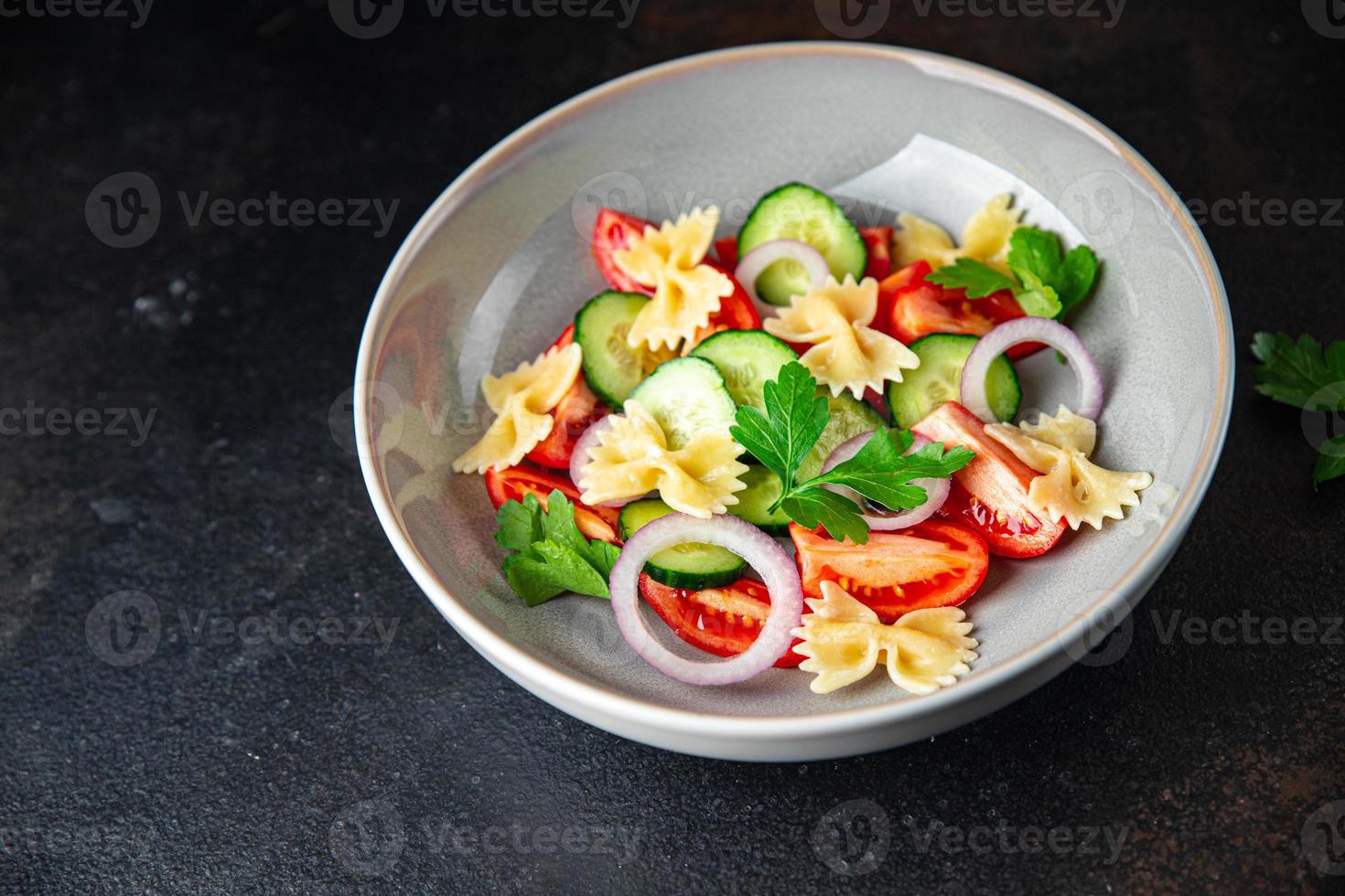 ensalada de pasta farfalle, tomate, pepino, cebolla comida sana dieta foto
