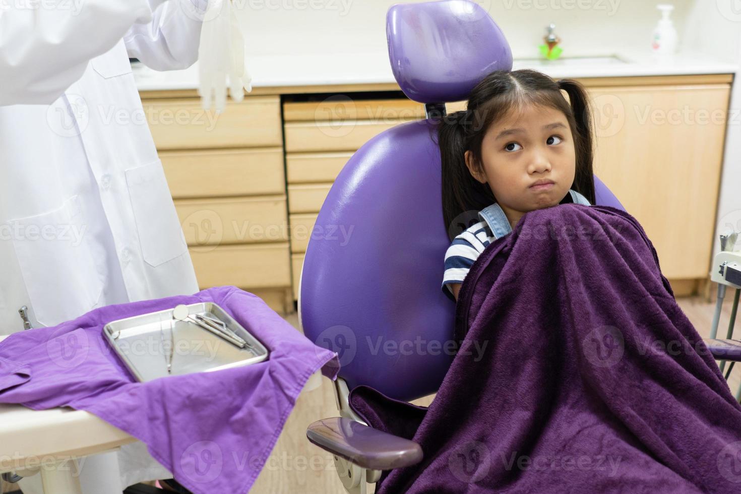 Young Girl Feeling scare When Dentist Clean Her Teeth in Dental Clinic photo