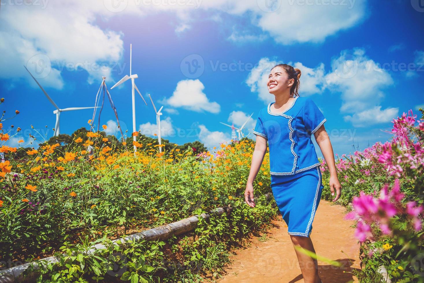 las mujeres asiáticas viajan dormir relajarse. las mujeres se visten de la tribu de las colinas. caminar en el jardín de flores cosmos sulphureus. tailandia foto