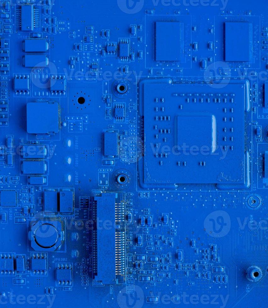 Computer motherboard. Classic blue background with pc backdrop, close up. Single color microchip photo