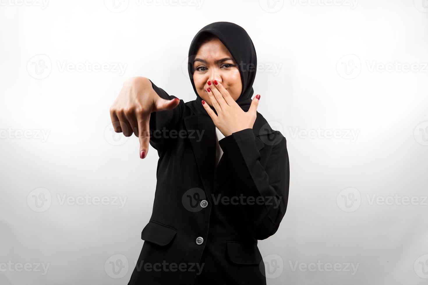 Hermosa joven mujer de negocios musulmana con la mano cubriendo la boca, la mano apuntando hacia abajo, mostrando expresión de desaprobación, mostrando disgusto por algo, aislado sobre fondo blanco. foto