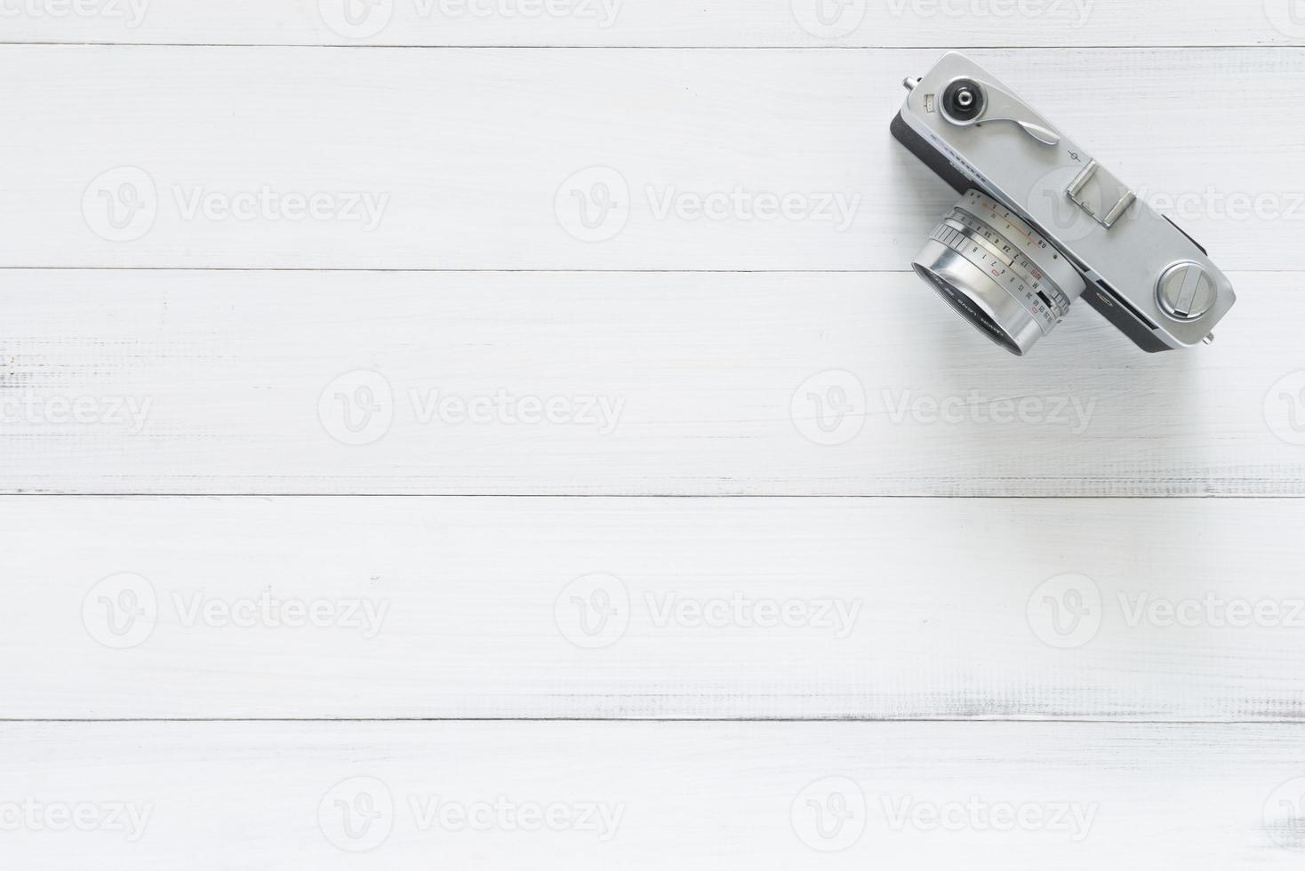 Minimal work space - Creative flat lay photo of workspace desk. Office desk wooden table with old camera. Top view with copy space. Top view of old camera over wooden table. Retro vintage filter.