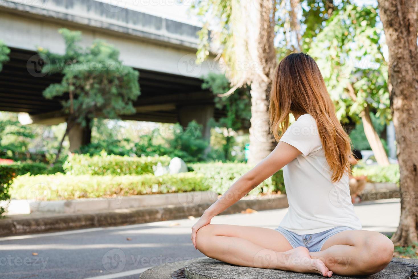 Young asian woman yoga outdoors keep calm and meditates while practicing yoga to explore the inner peace. Yoga and meditation have good benefits for health. Yoga Sport and Healthy lifestyle concept. photo