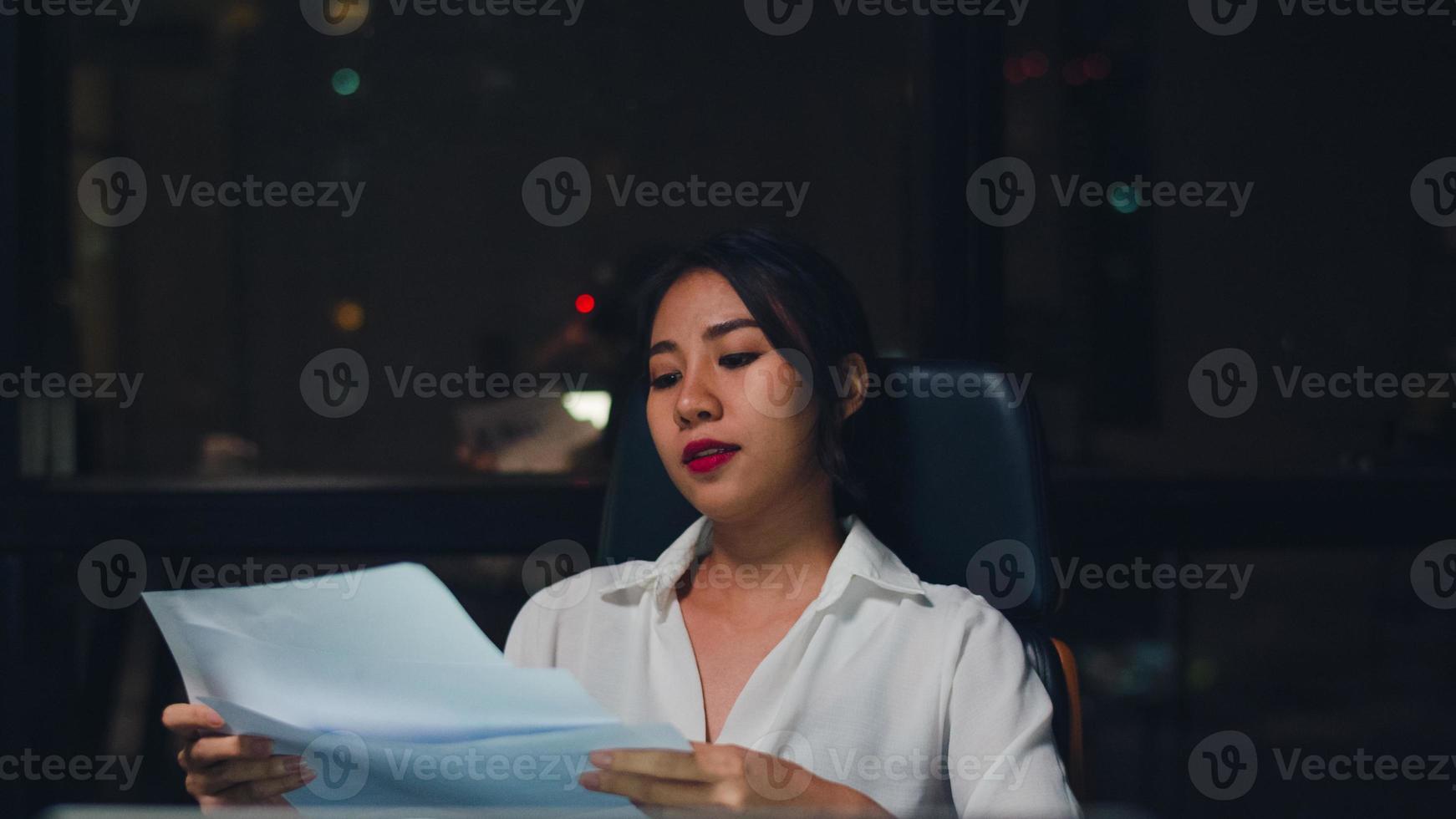 Millennial young Chinese businesswoman working late night stress out with project research problem on laptop in meeting room at small modern office. Asia people occupational burnout syndrome concept. photo