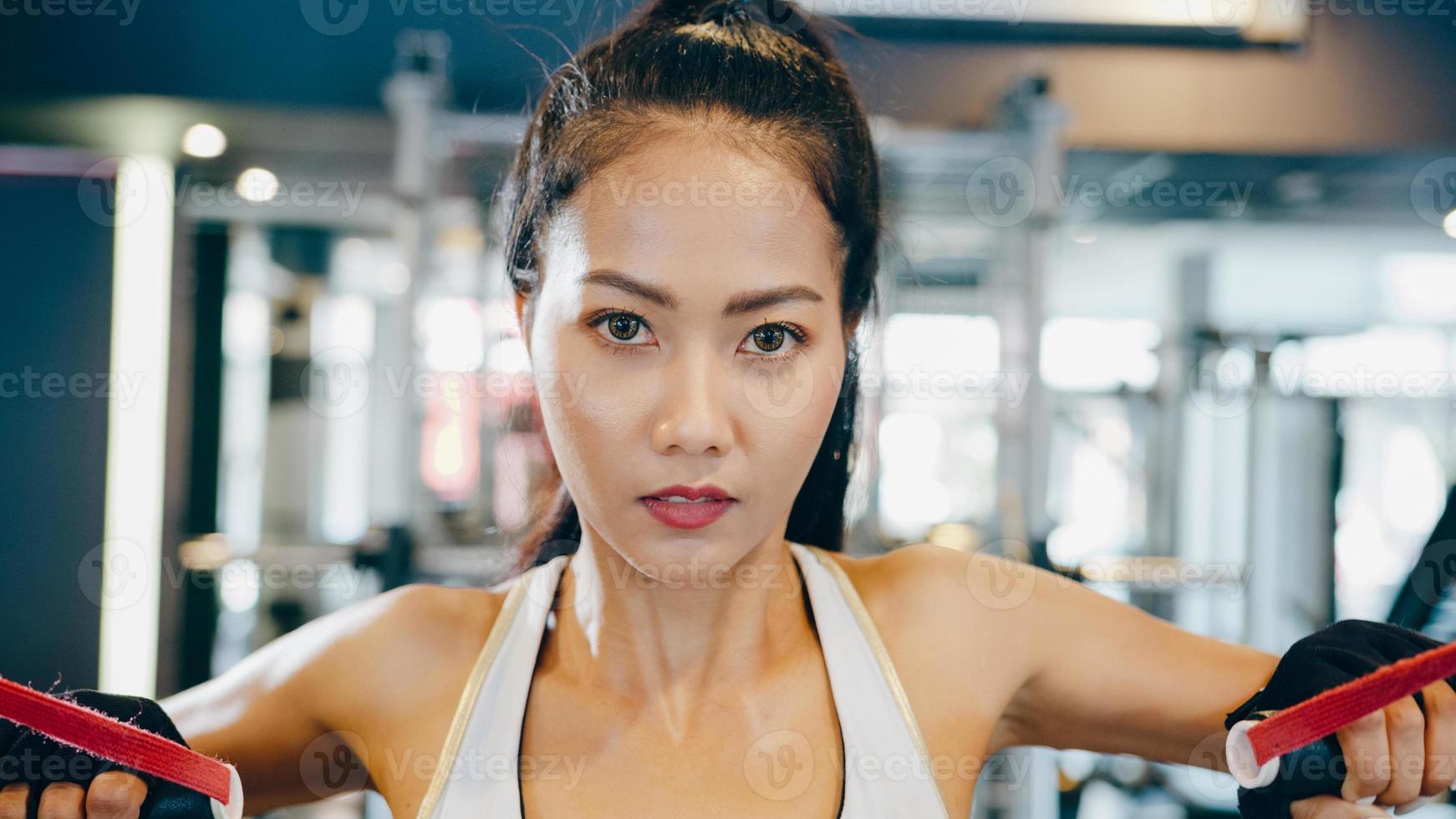 Asia joven dama ejercicio haciendo ejercicio-máquina de cable cruzado ejercicios para quemar grasa en la clase de gimnasia. atleta con six pack, actividad recreativa deportista, entrenamiento funcional, estilo de vida saludable. foto