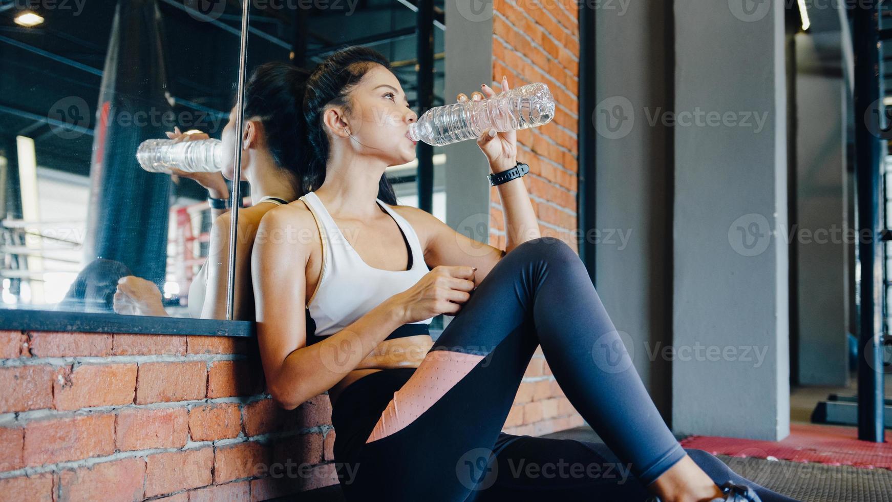 Beautiful young Asia lady exercise drinking water after fat burning workout in fitness class. Athlete with six pack, Sportswoman recreational activity, functional training, healthy lifestyle concept. photo