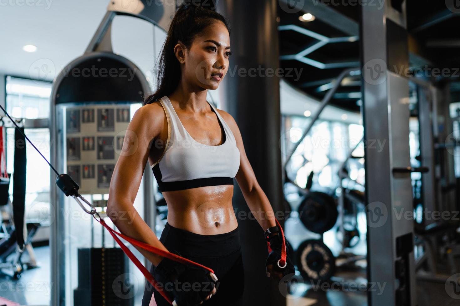 Asia joven dama ejercicio haciendo ejercicio-máquina de cable cruzado ejercicios para quemar grasa en la clase de gimnasia. atleta con six pack, actividad recreativa deportista, entrenamiento funcional, estilo de vida saludable. foto