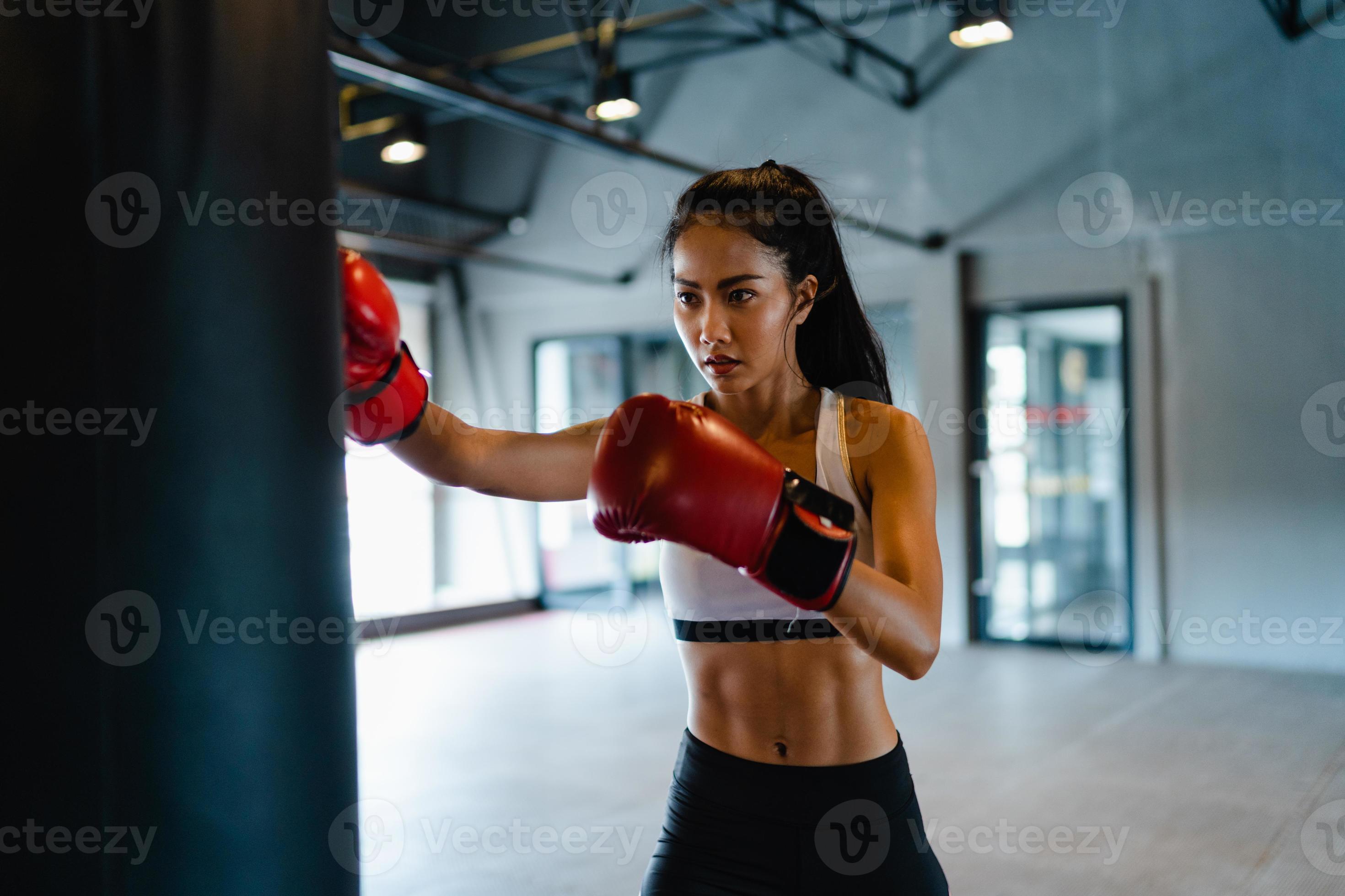 Young Asia lady kickboxing exercise workout punching bag tough female  fighter practice boxing in gym fitness class. Sportswoman recreational  activity, functional training, healthy lifestyle concept. Stock Photo