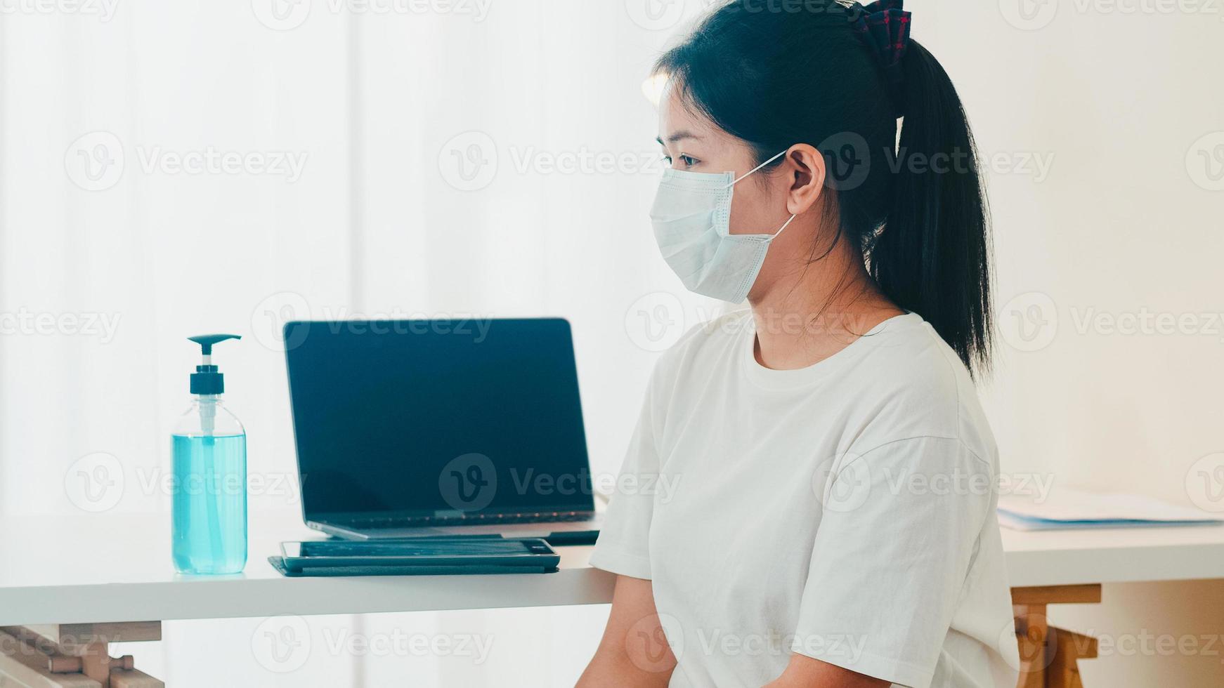 Asian woman using alcohol gel hand sanitizer wash hand before open tablet for protect coronavirus. Female push alcohol to clean for hygiene when social distancing stay at home and self quarantine time photo