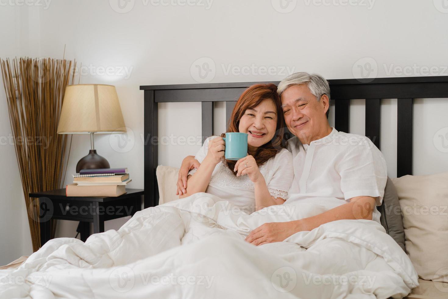 pareja senior asiática hablando en la cama en casa. Abuelos chinos mayores  asiáticos, esposo y esposa