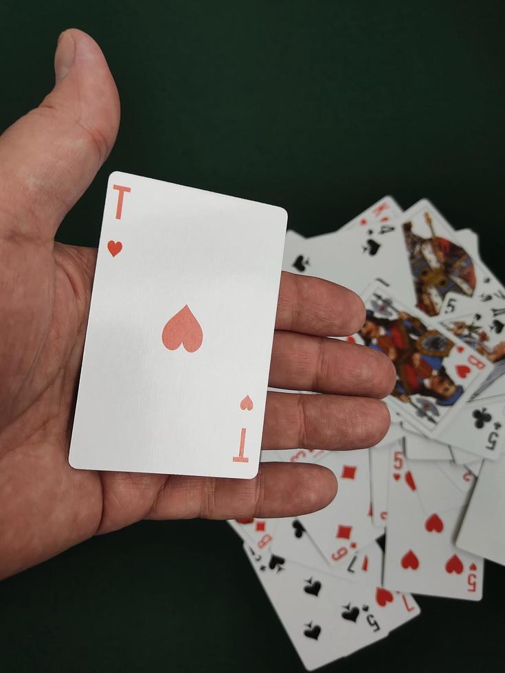 la mano del hombre arroja una baraja de cartas sobre la mesa de juego. foto