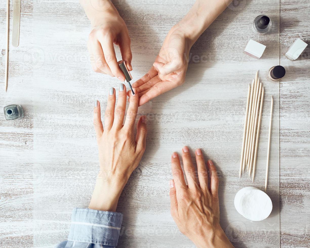 madre e hija hacen manicura, pintan uñas con barniz. autocuidado en el hogar durante la cuarentena foto