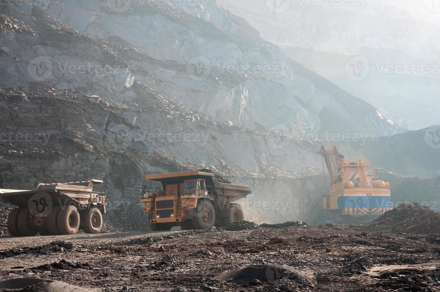 Los camiones volquete de mina a cielo abierto conducen solo zona industrial de la cantera de mineral de hierro foto