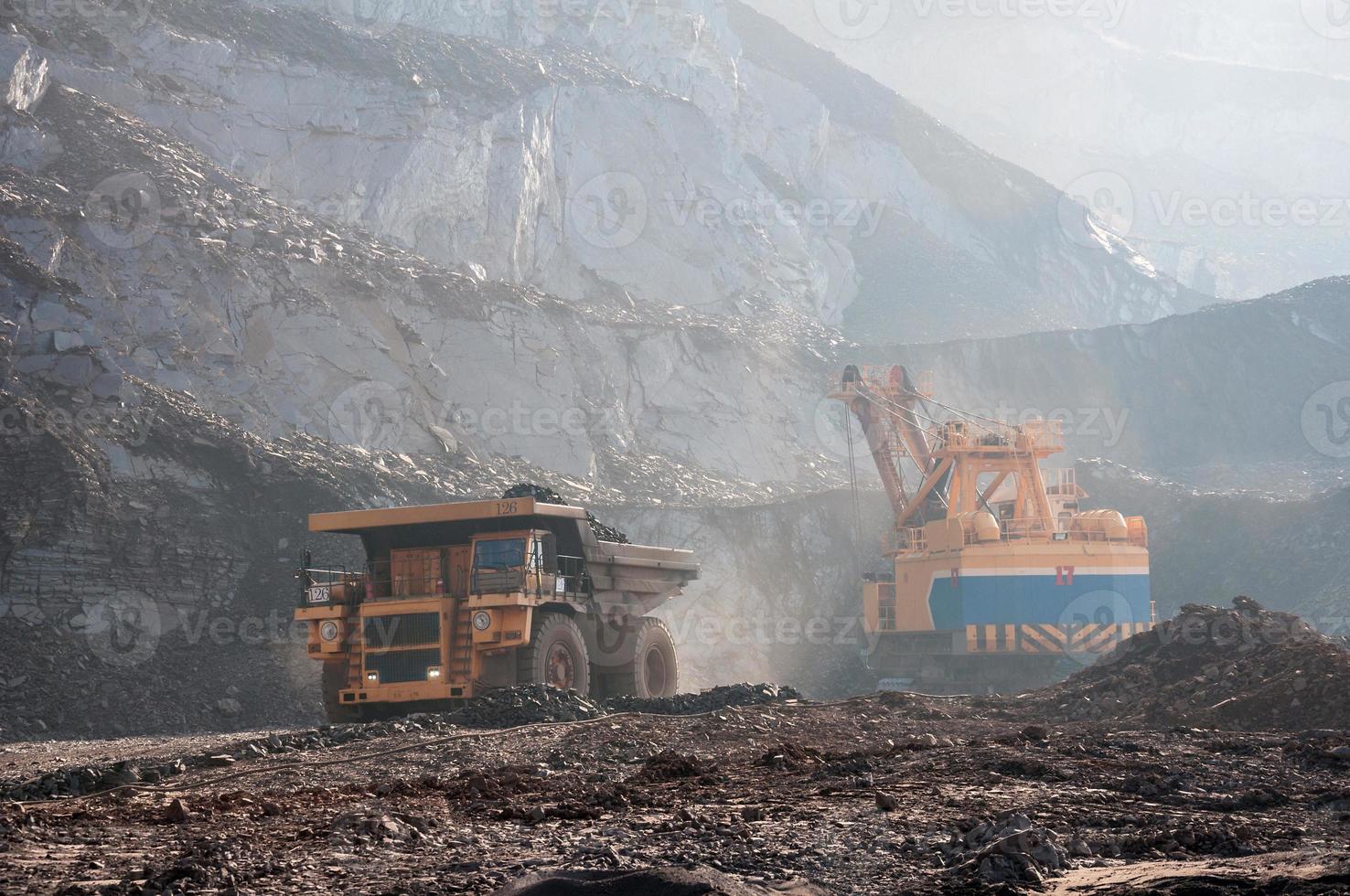 open cast mine dump trucks drive alone industrial area of iron ore quarry photo