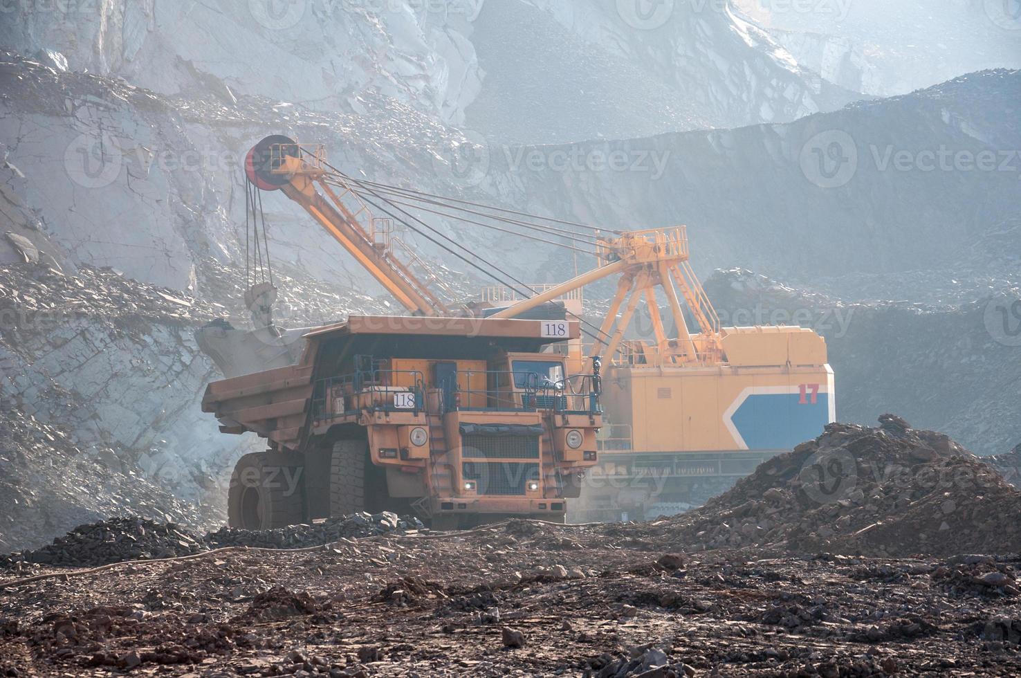 Los camiones volquete de mina a cielo abierto conducen solo zona industrial de la cantera de mineral de hierro foto