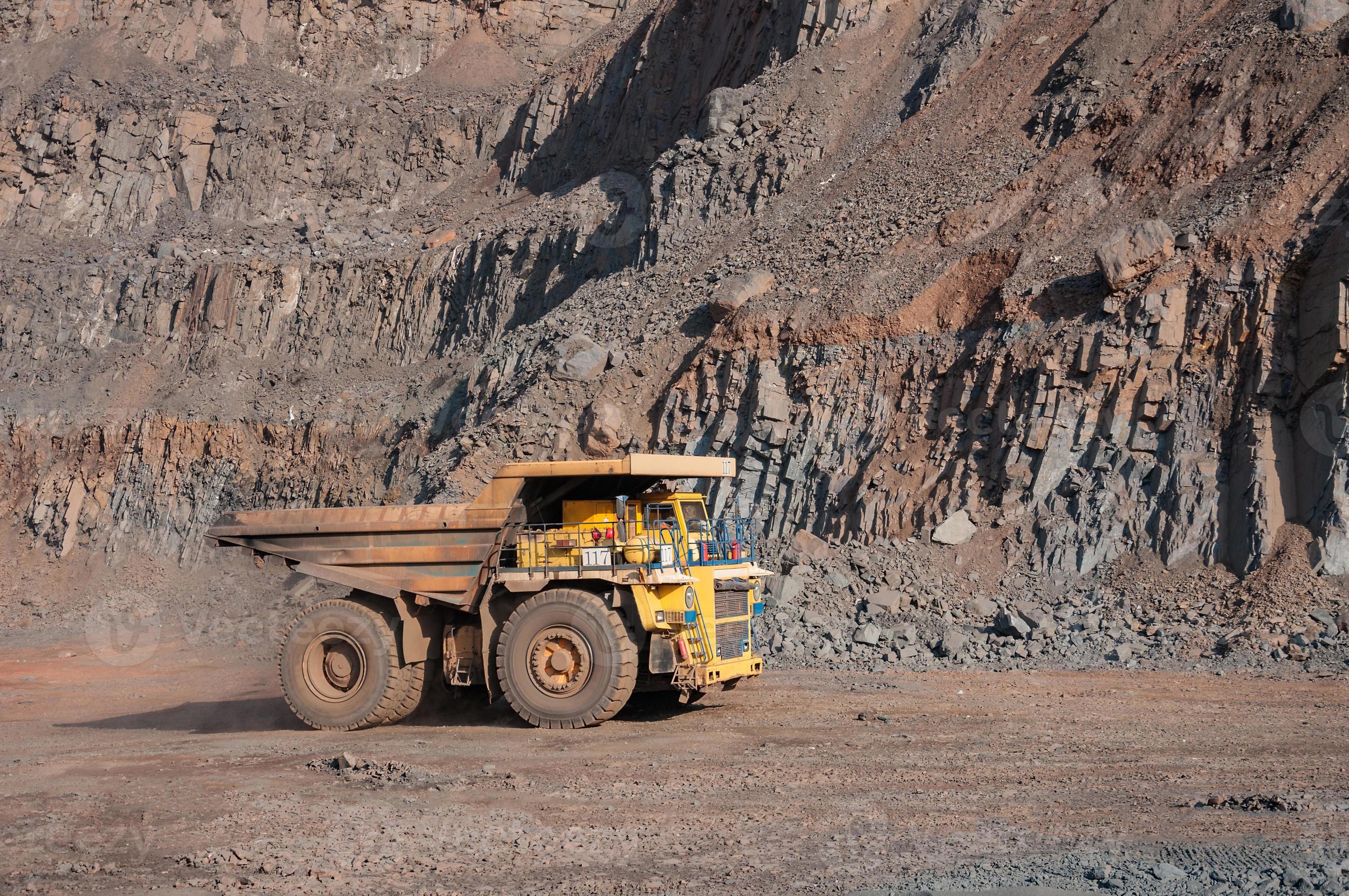 Los camiones volquete de mina a cielo abierto conducen solo zona industrial de la cantera de mineral de hierro foto