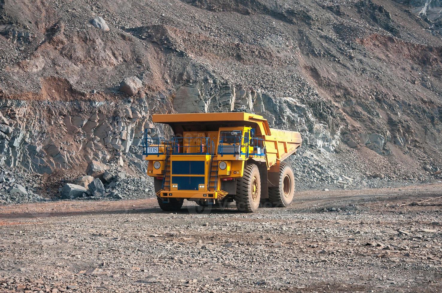 Los camiones volquete de mina a cielo abierto conducen solo zona industrial de la cantera de mineral de hierro foto