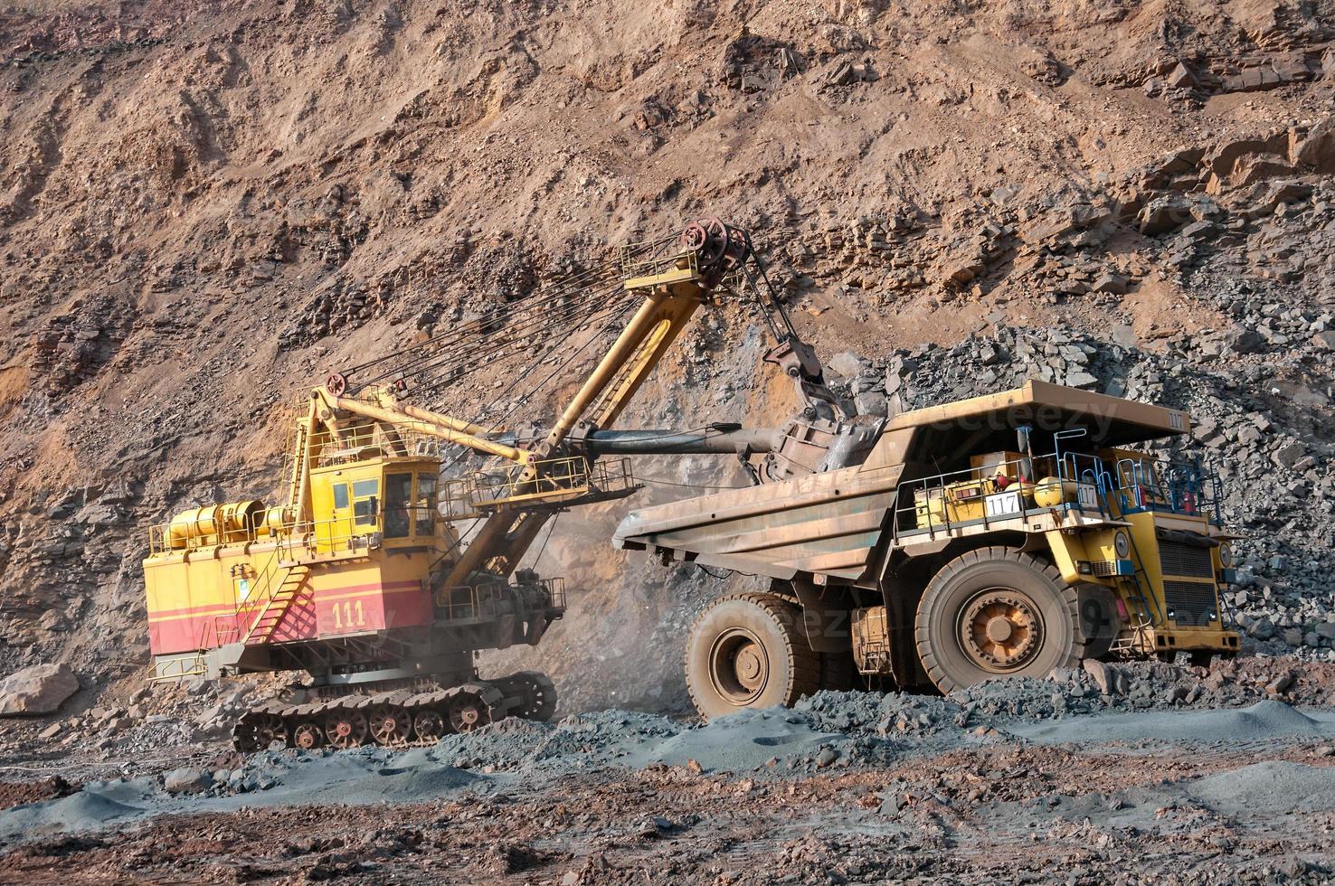 Los camiones volquete de mina a cielo abierto conducen solo zona industrial de la cantera de mineral de hierro foto