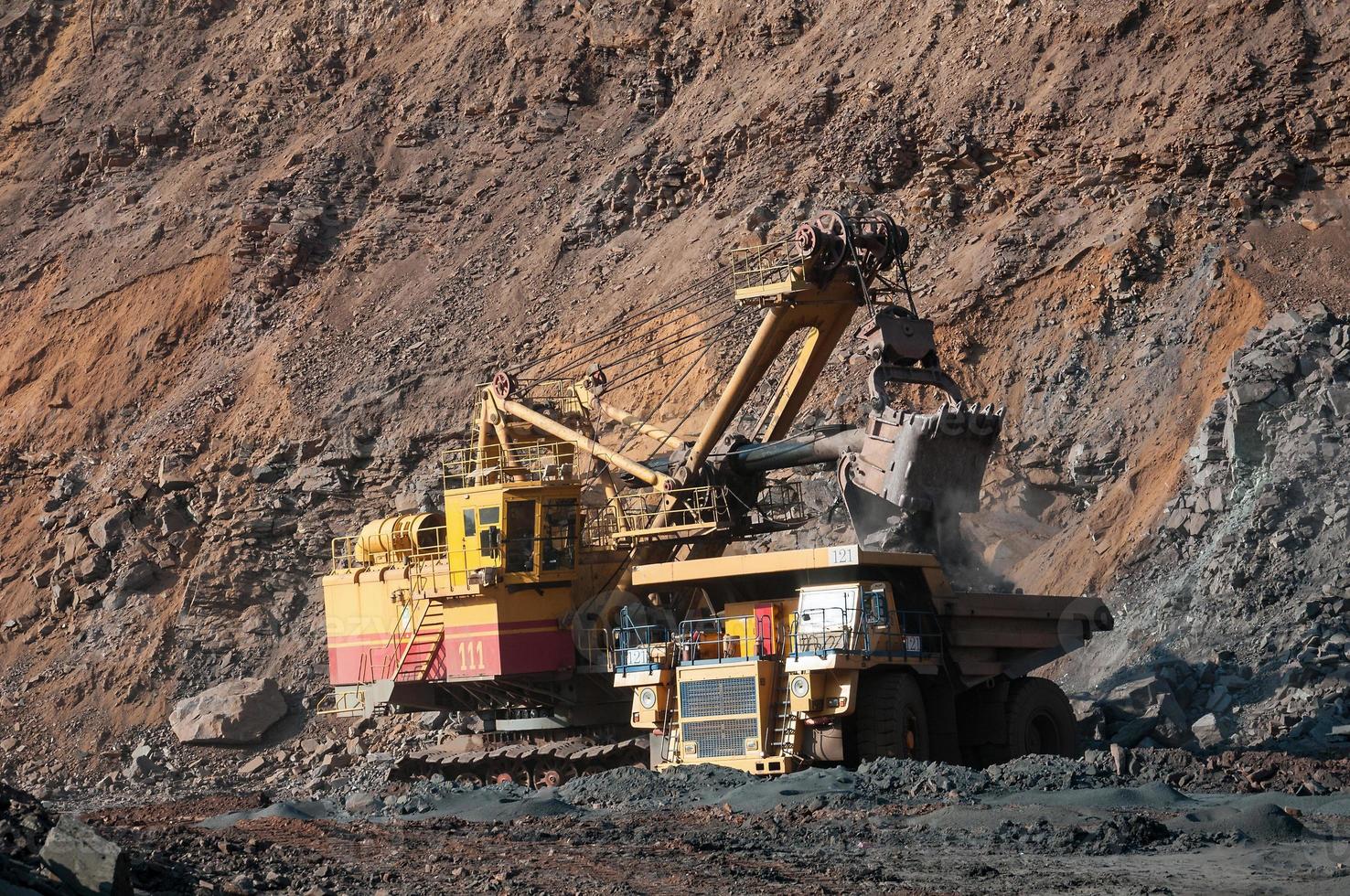 Los camiones volquete de mina a cielo abierto conducen solo zona industrial de la cantera de mineral de hierro foto