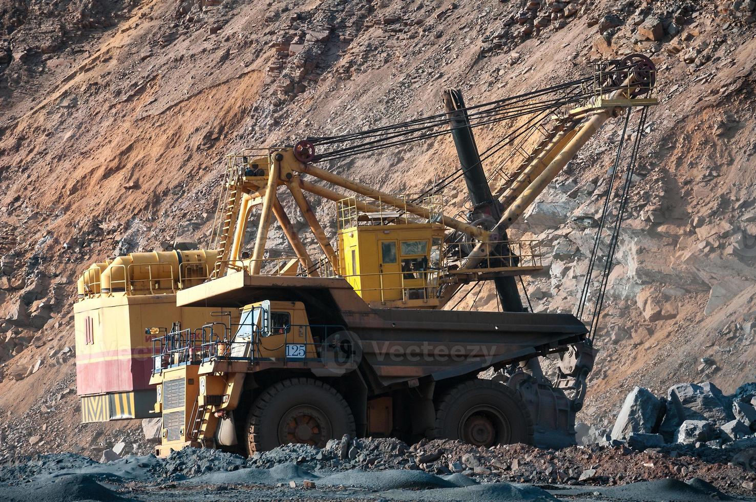 Los camiones volquete de mina a cielo abierto conducen solo zona industrial de la cantera de mineral de hierro foto