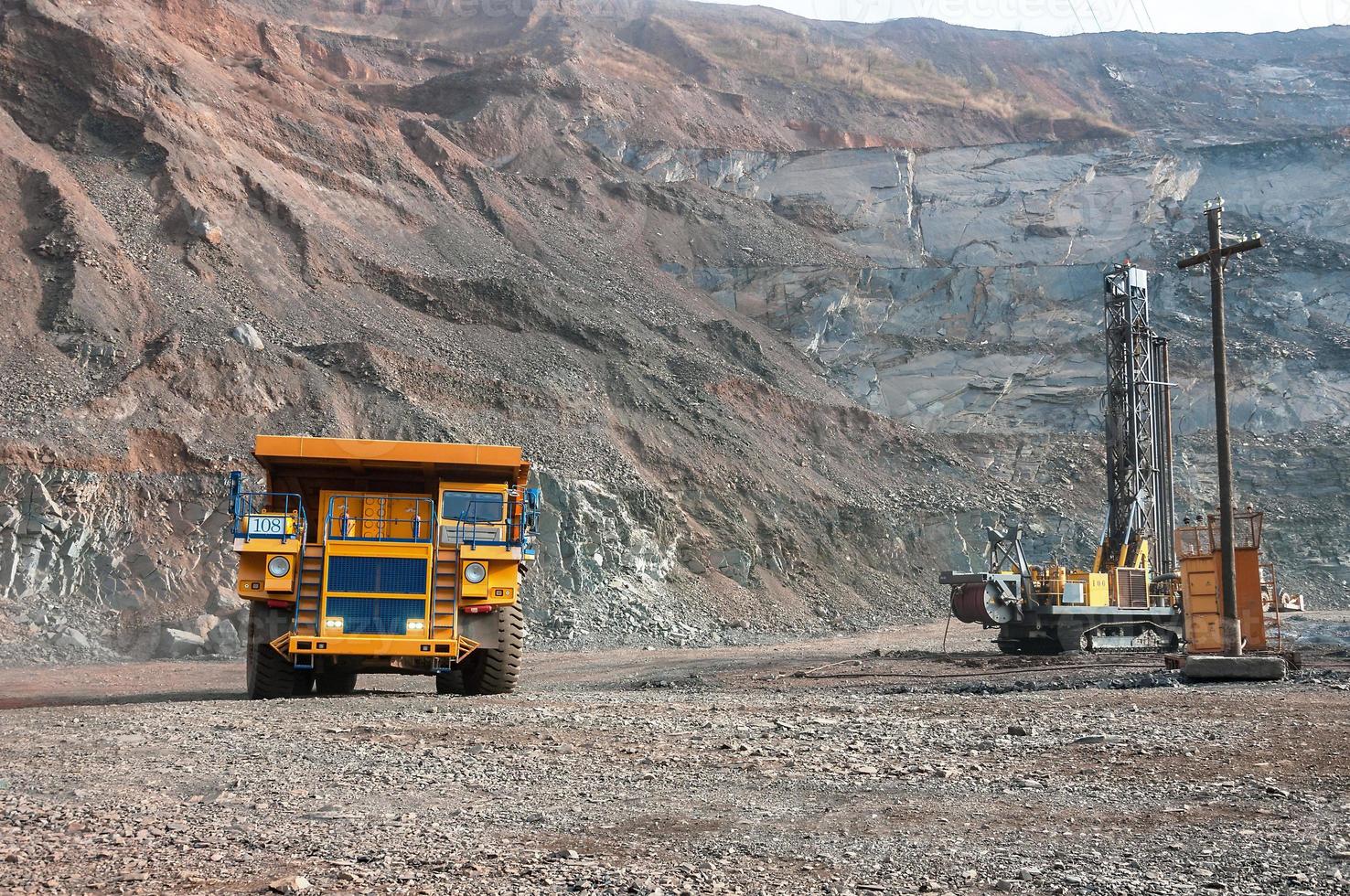 Los camiones volquete de mina a cielo abierto conducen solo zona industrial de la cantera de mineral de hierro foto