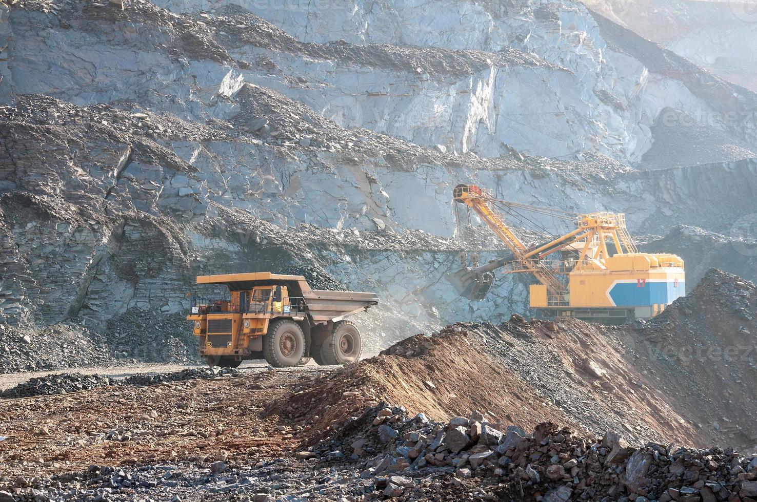 Los camiones volquete de mina a cielo abierto conducen solo zona industrial de la cantera de mineral de hierro foto