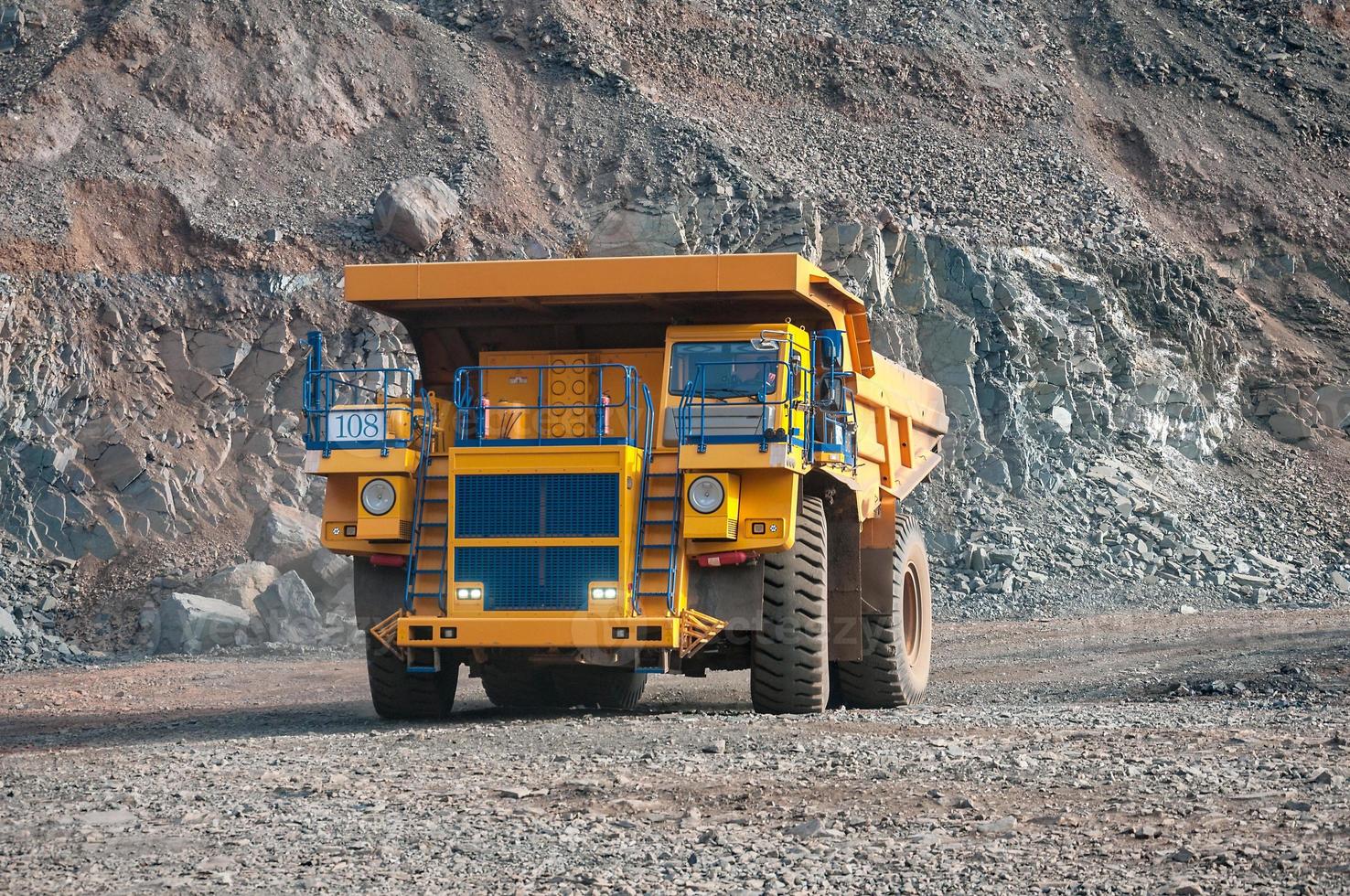 open cast mine dump trucks drive alone industrial area of iron ore quarry photo