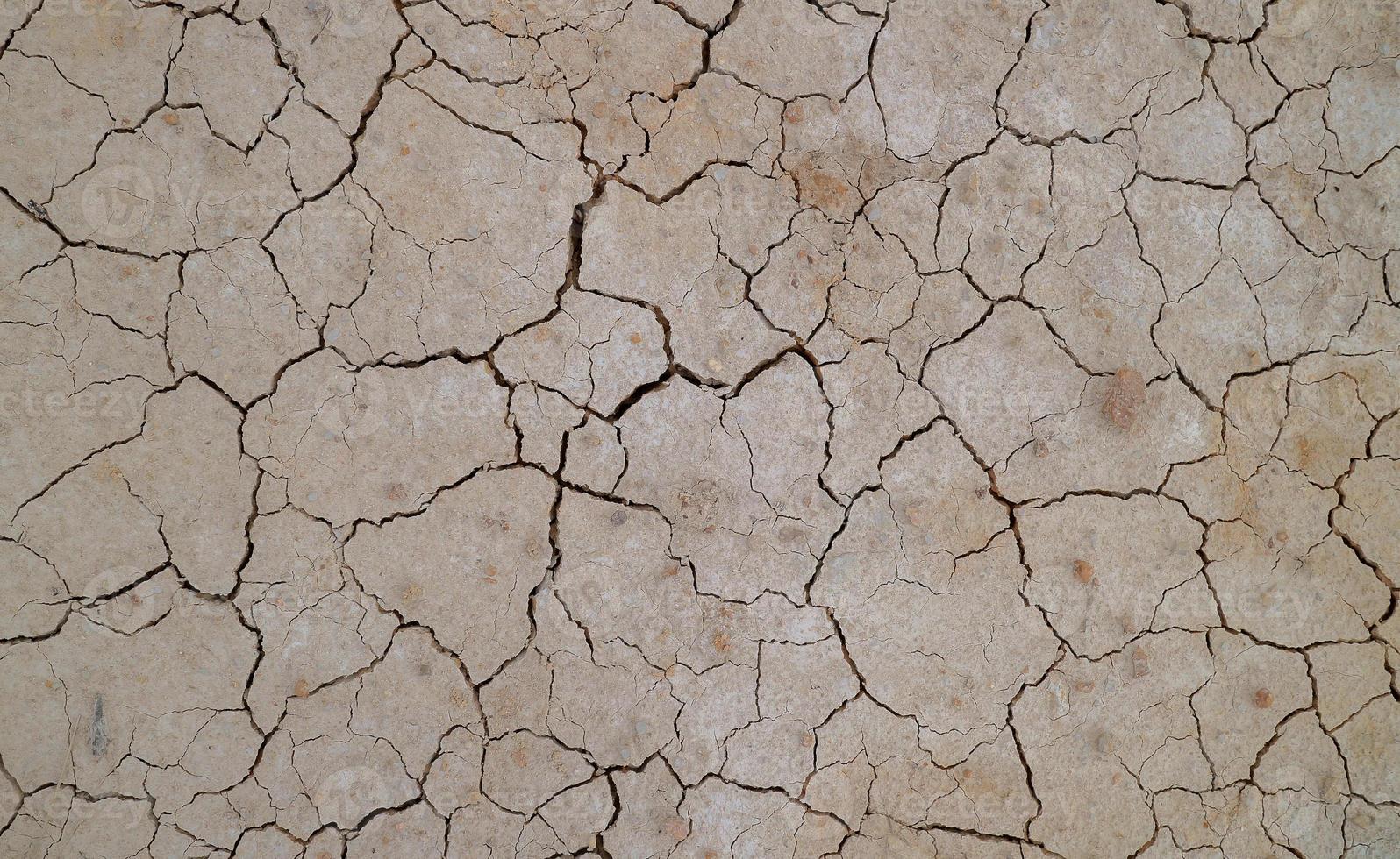 suelo agrietado debido a la sequía. la estación seca hace que el suelo se seque y se agriete foto