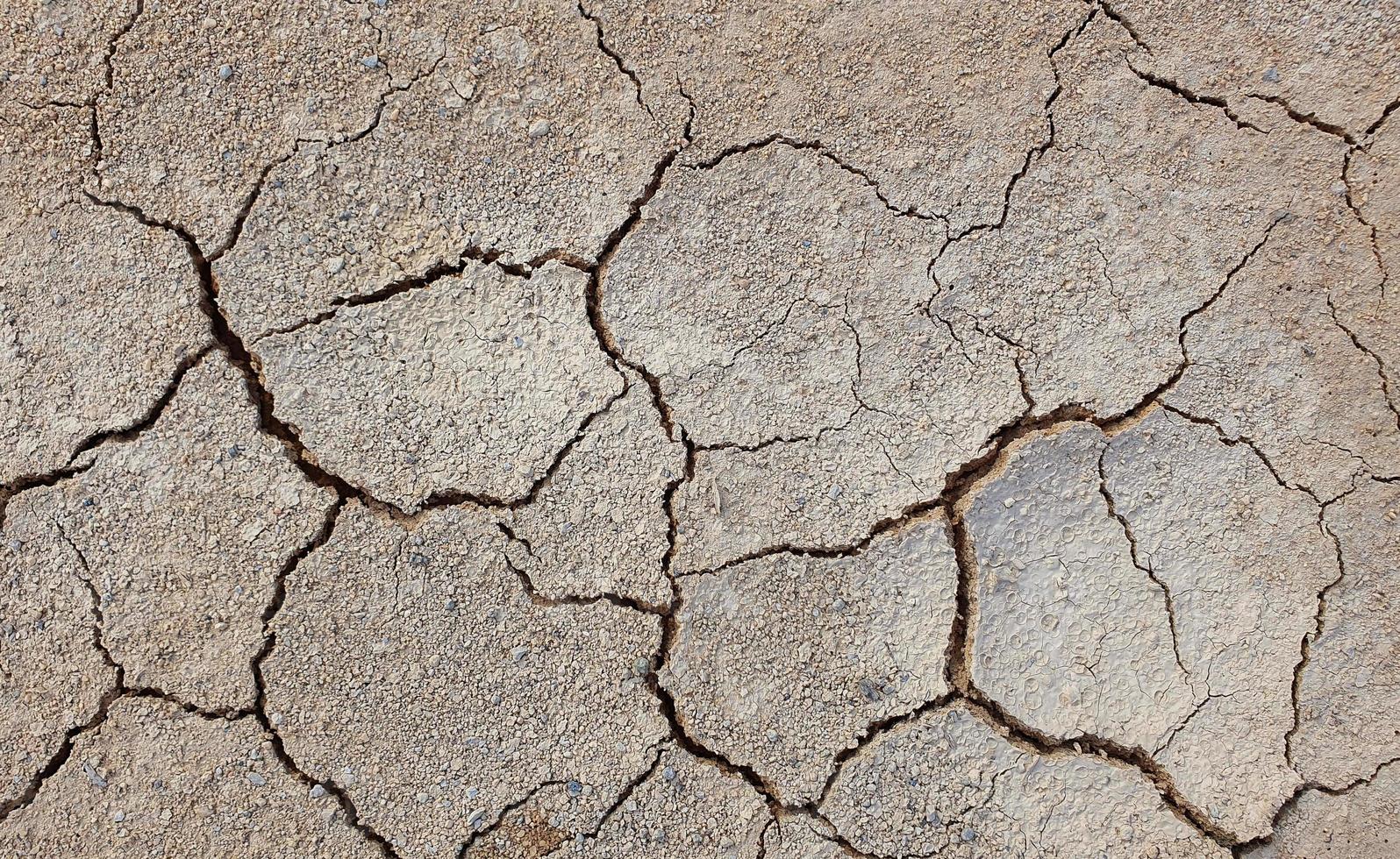 suelo agrietado debido a la sequía. la estación seca hace que el suelo se seque y se agriete foto