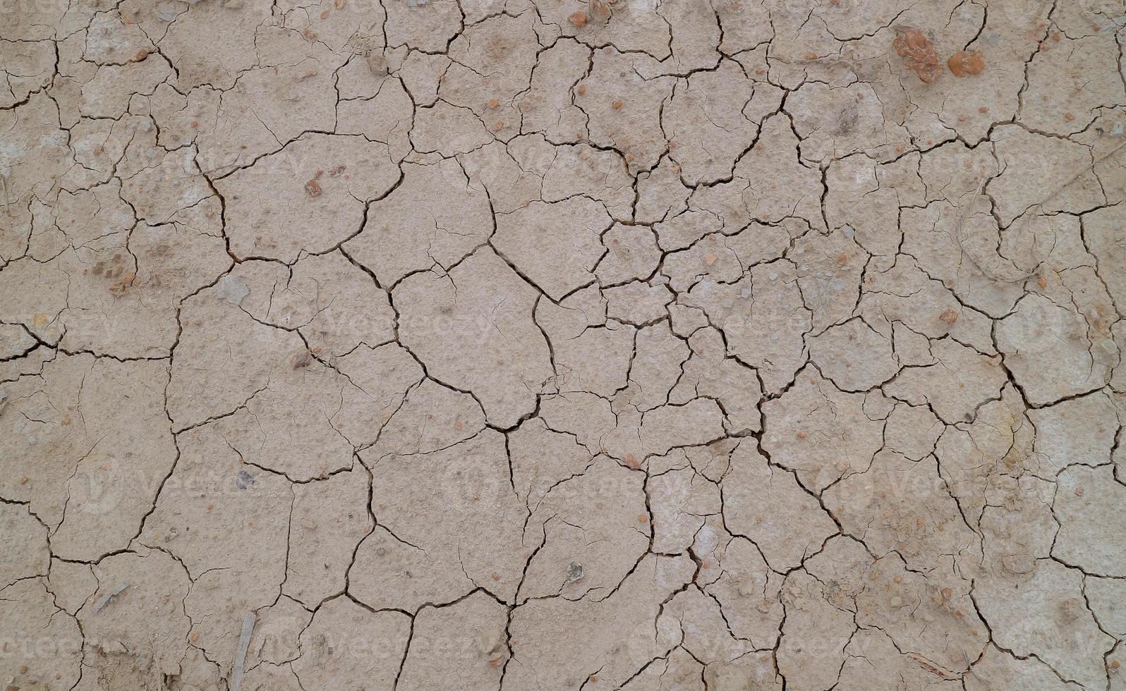 Ground cracked due to drought. Dry season causes the soil to dry and